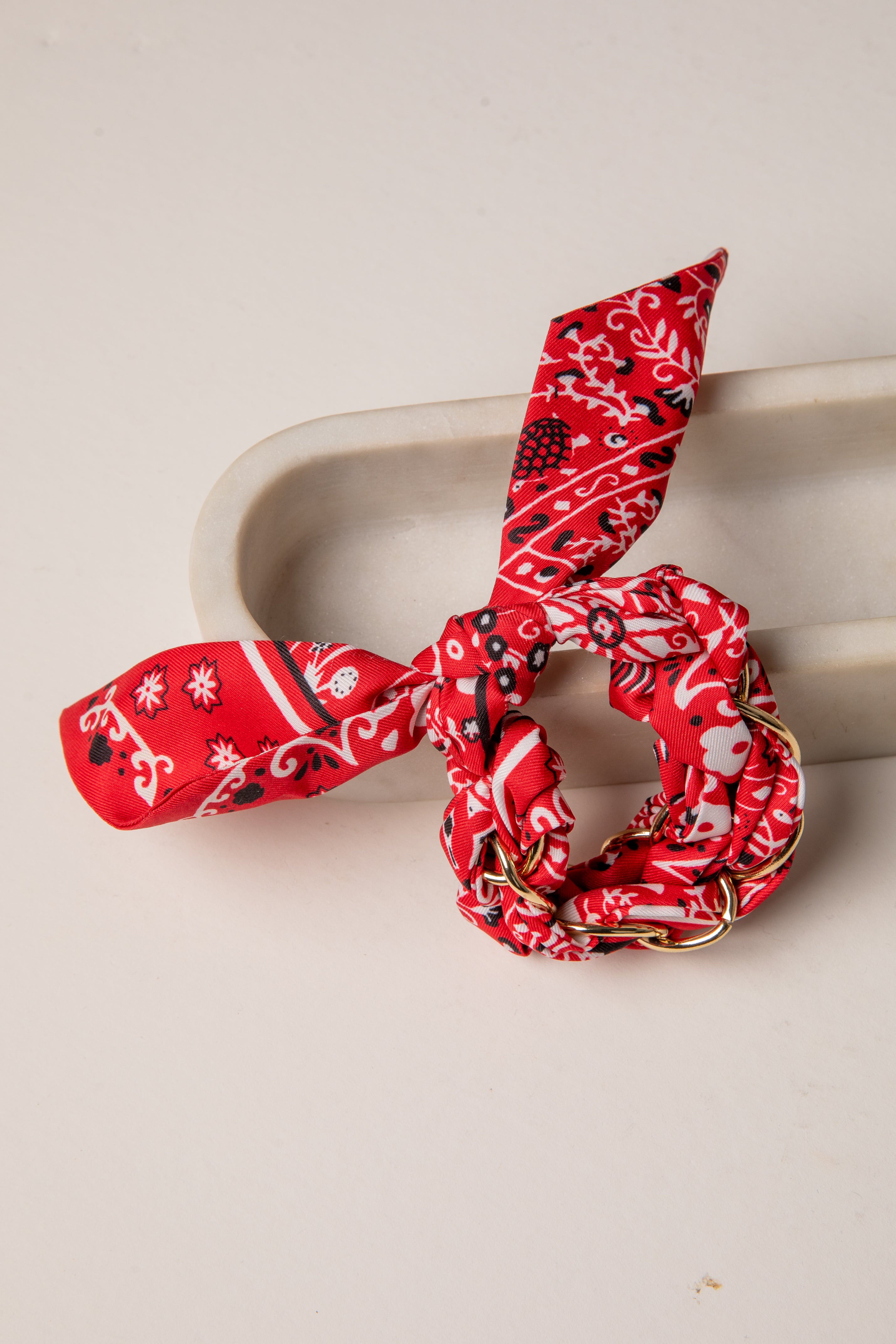 Red patterned hair scrunchie on a beige surface