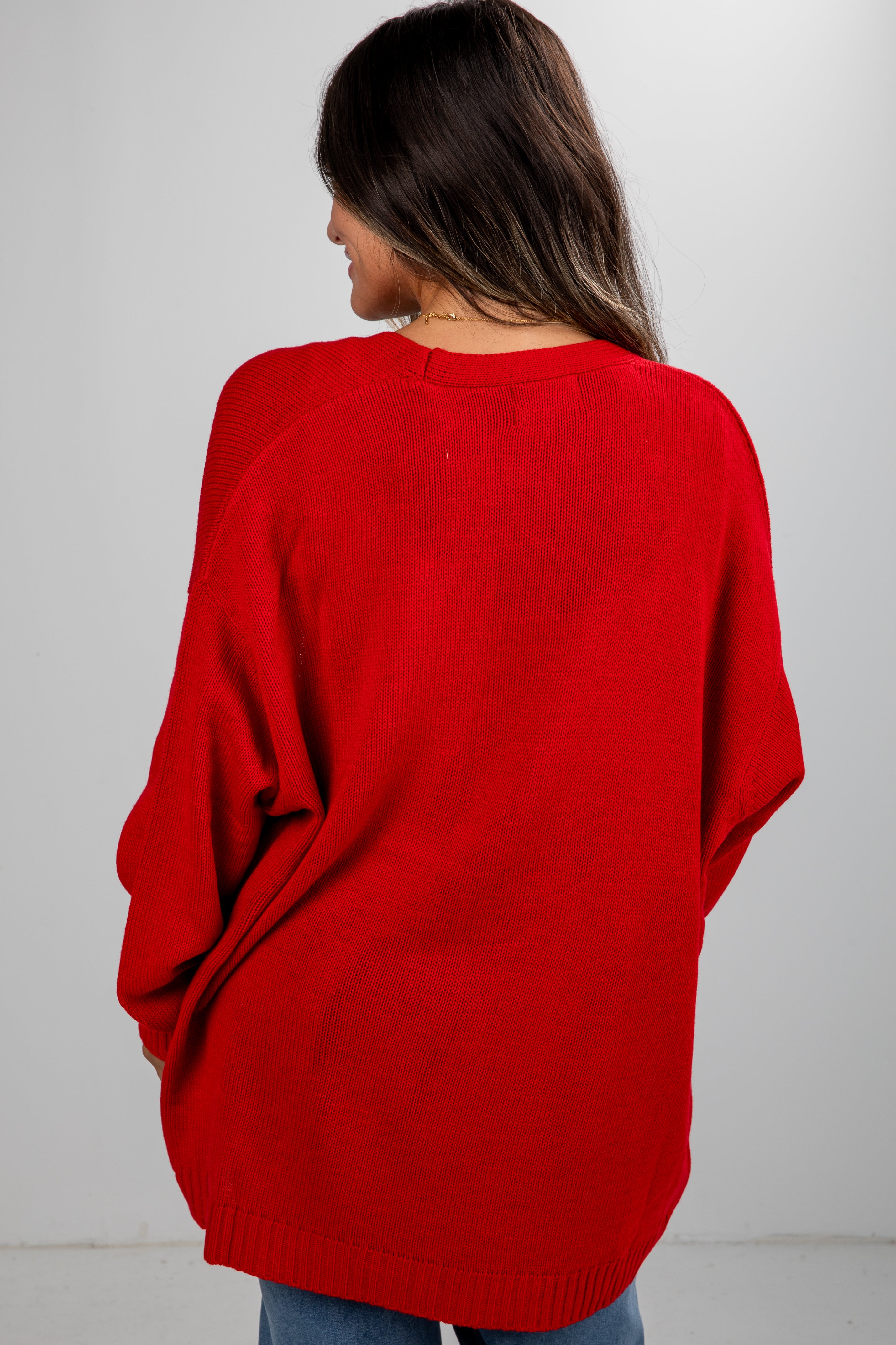Person wearing a red sweater against a white background