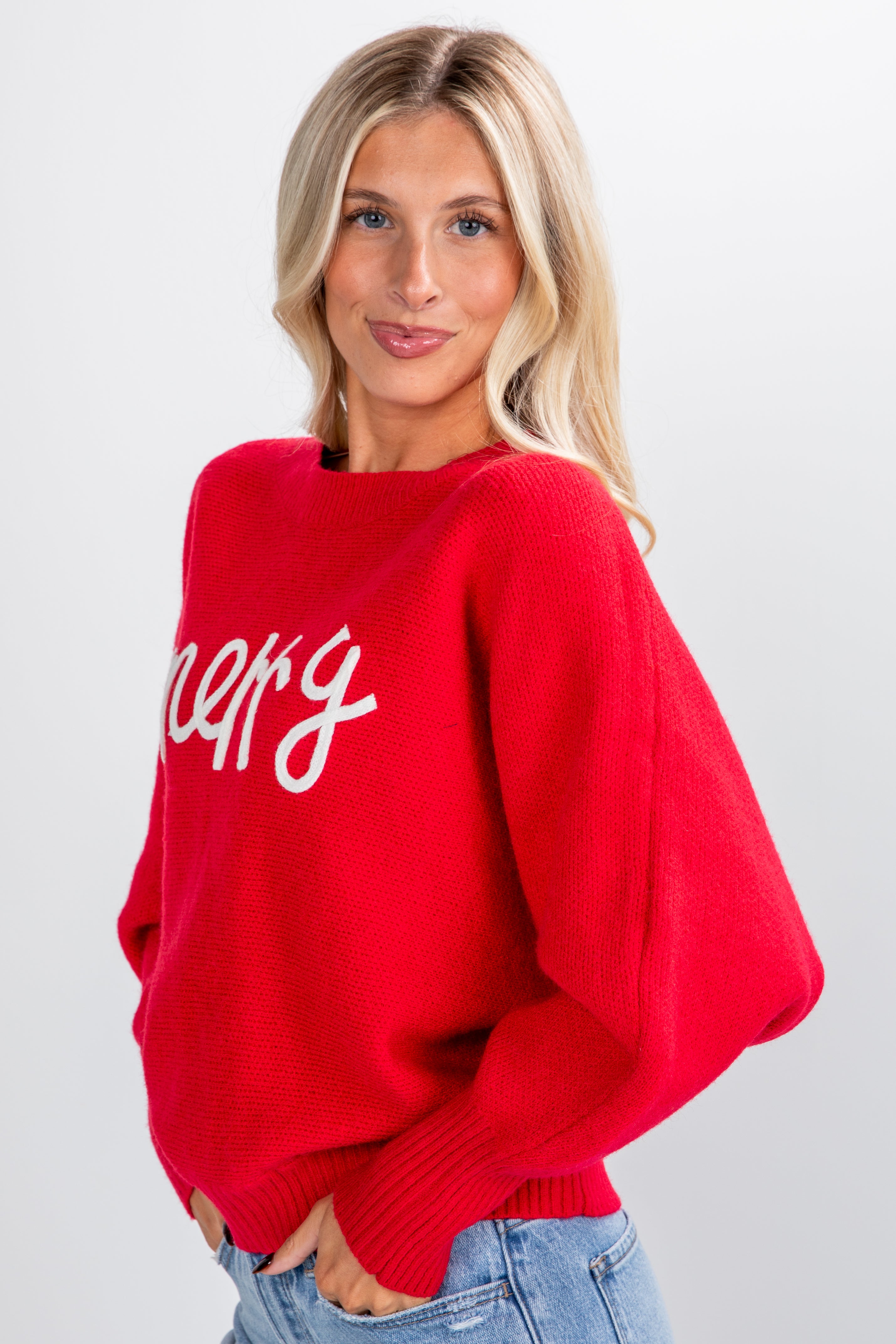 Woman wearing a red sweater with white text on a plain background