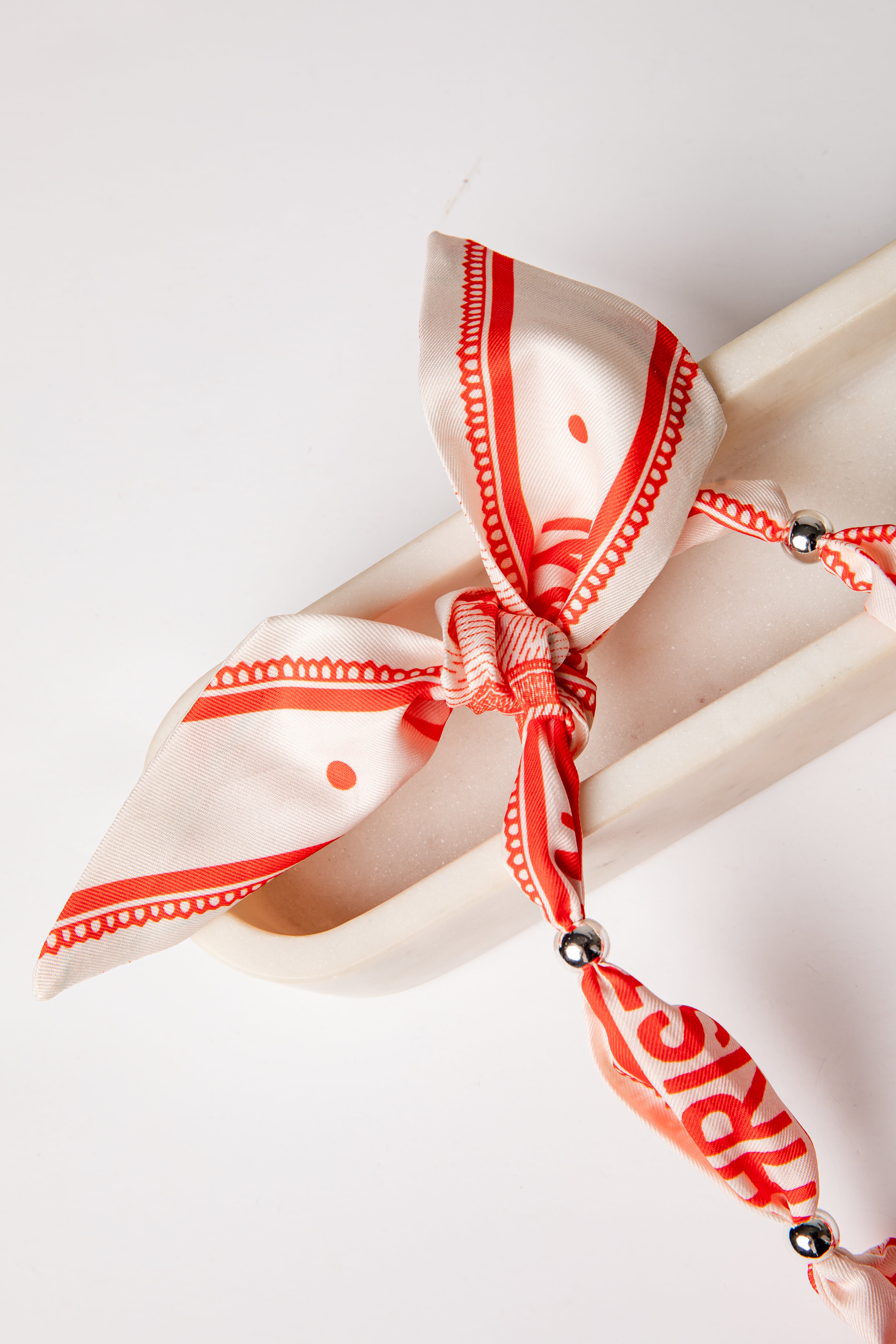 Napkin with a red and white striped ribbon tied around it on a white background