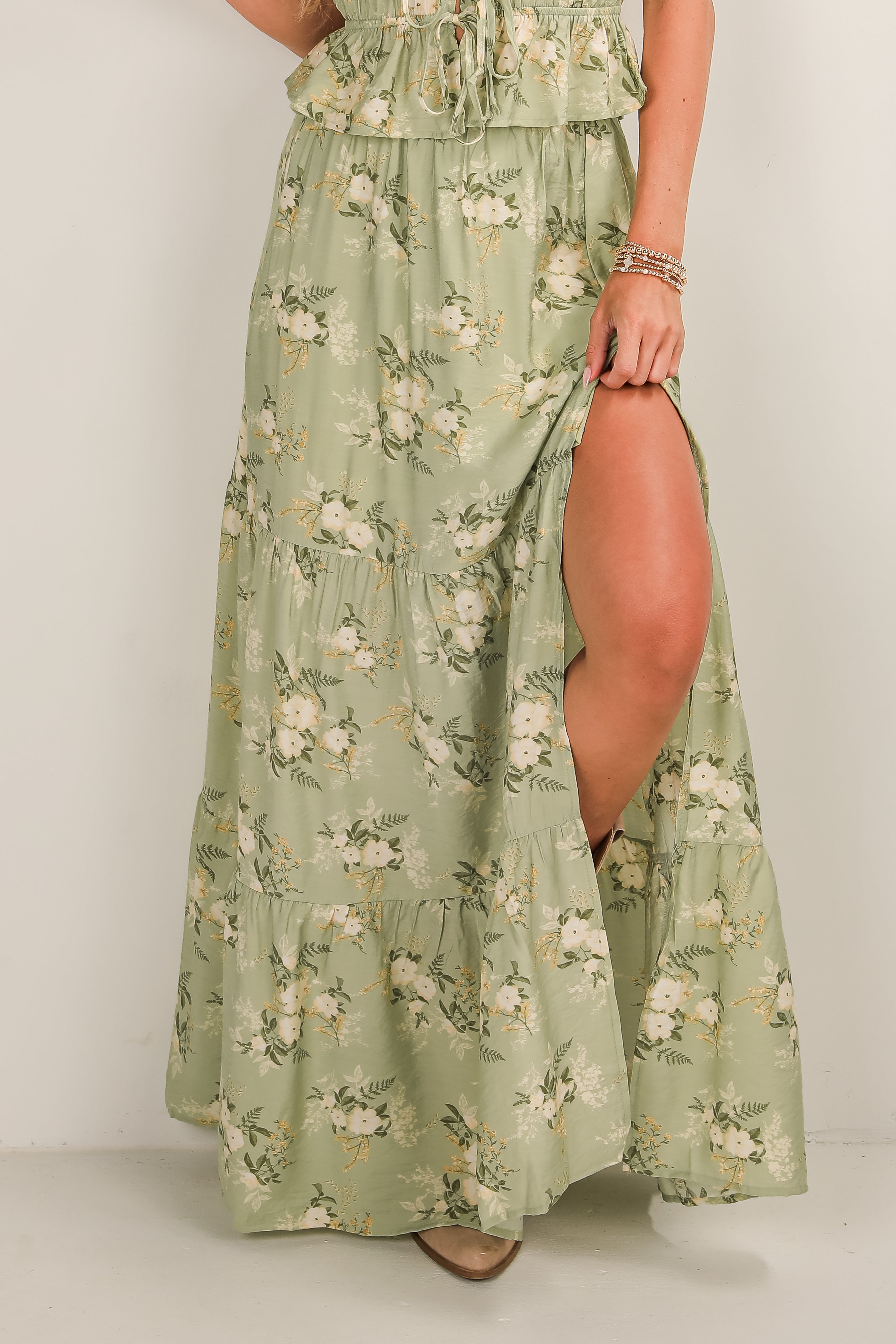 Green floral dress with a slit on a plain background