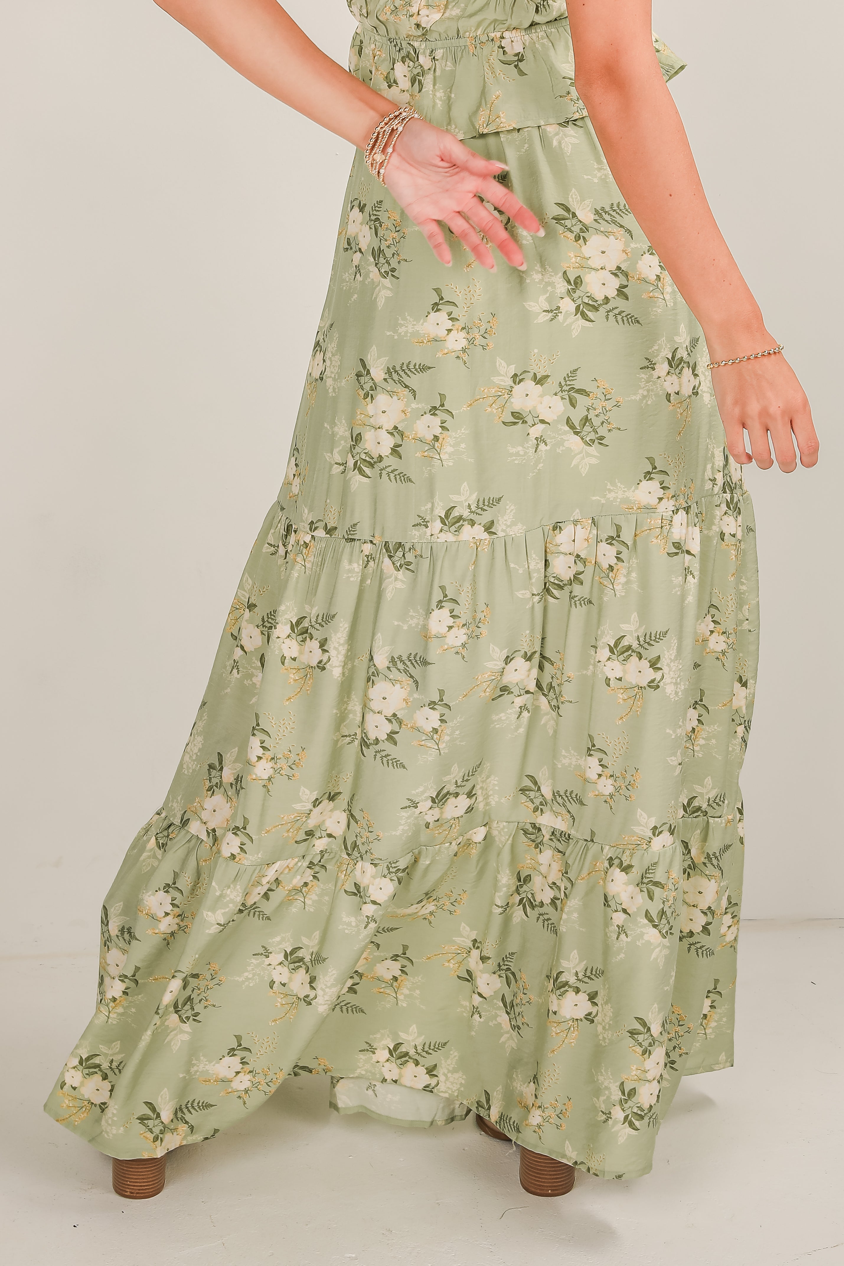 Green floral dress worn by a person on a white background