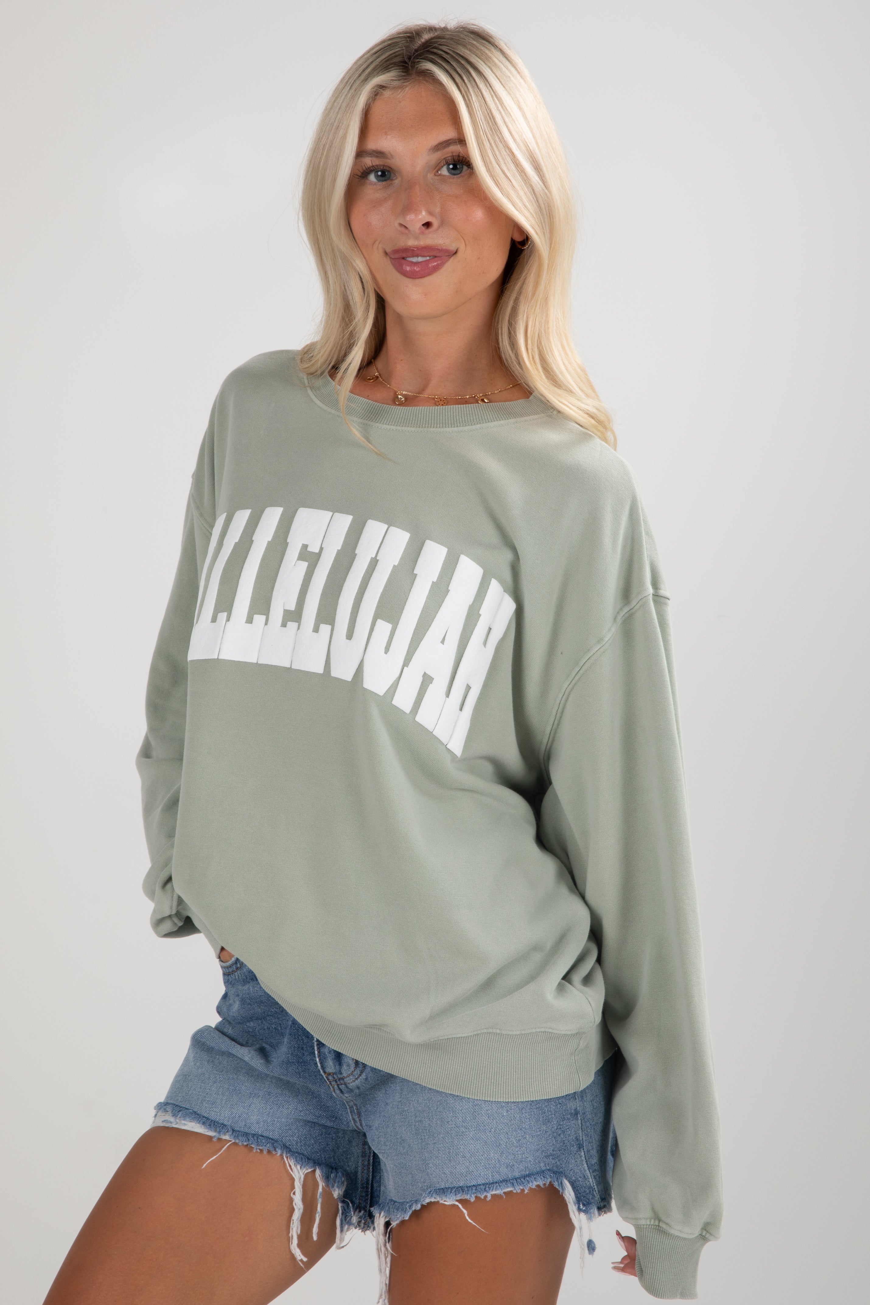 Woman wearing a green sweatshirt with &