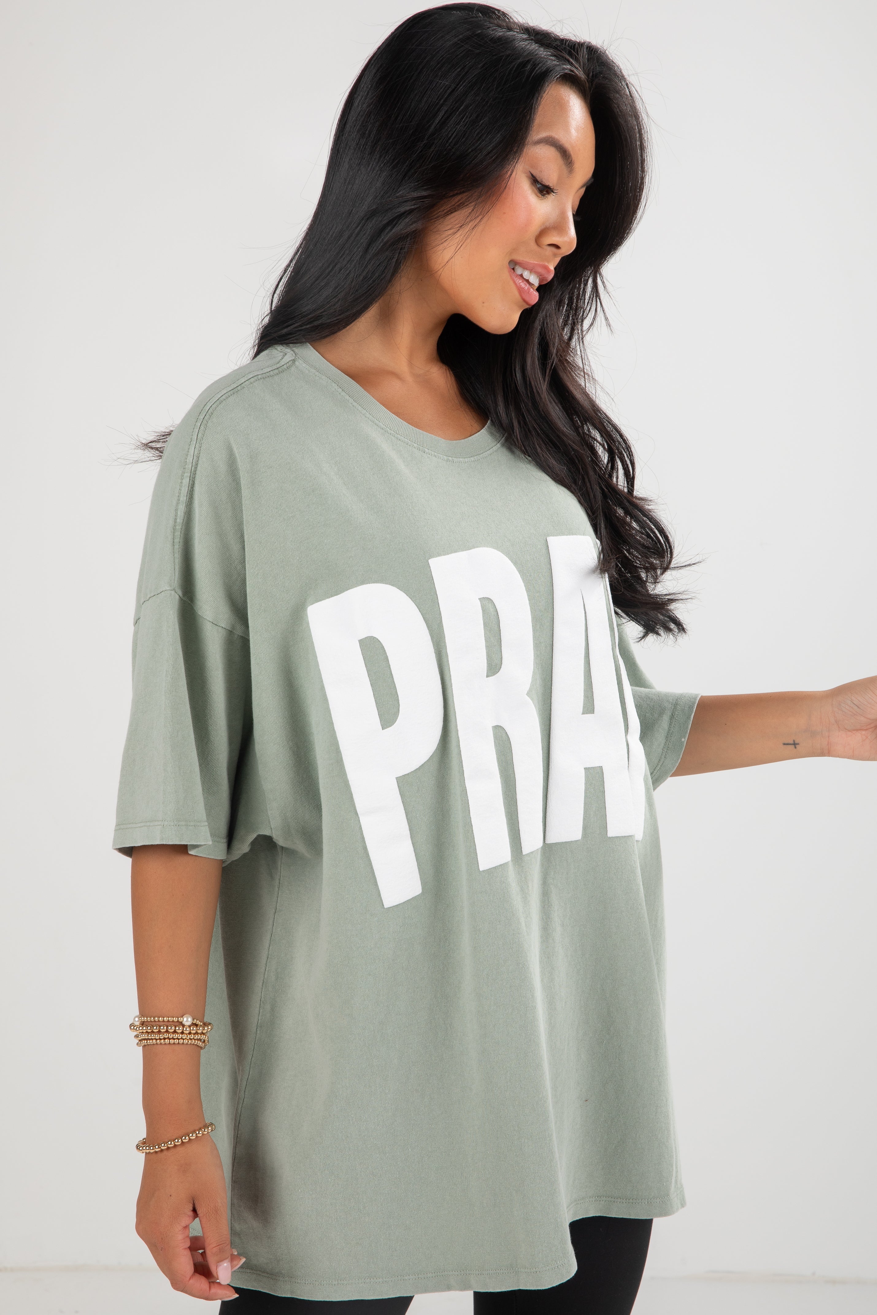Woman wearing a green t-shirt with &
