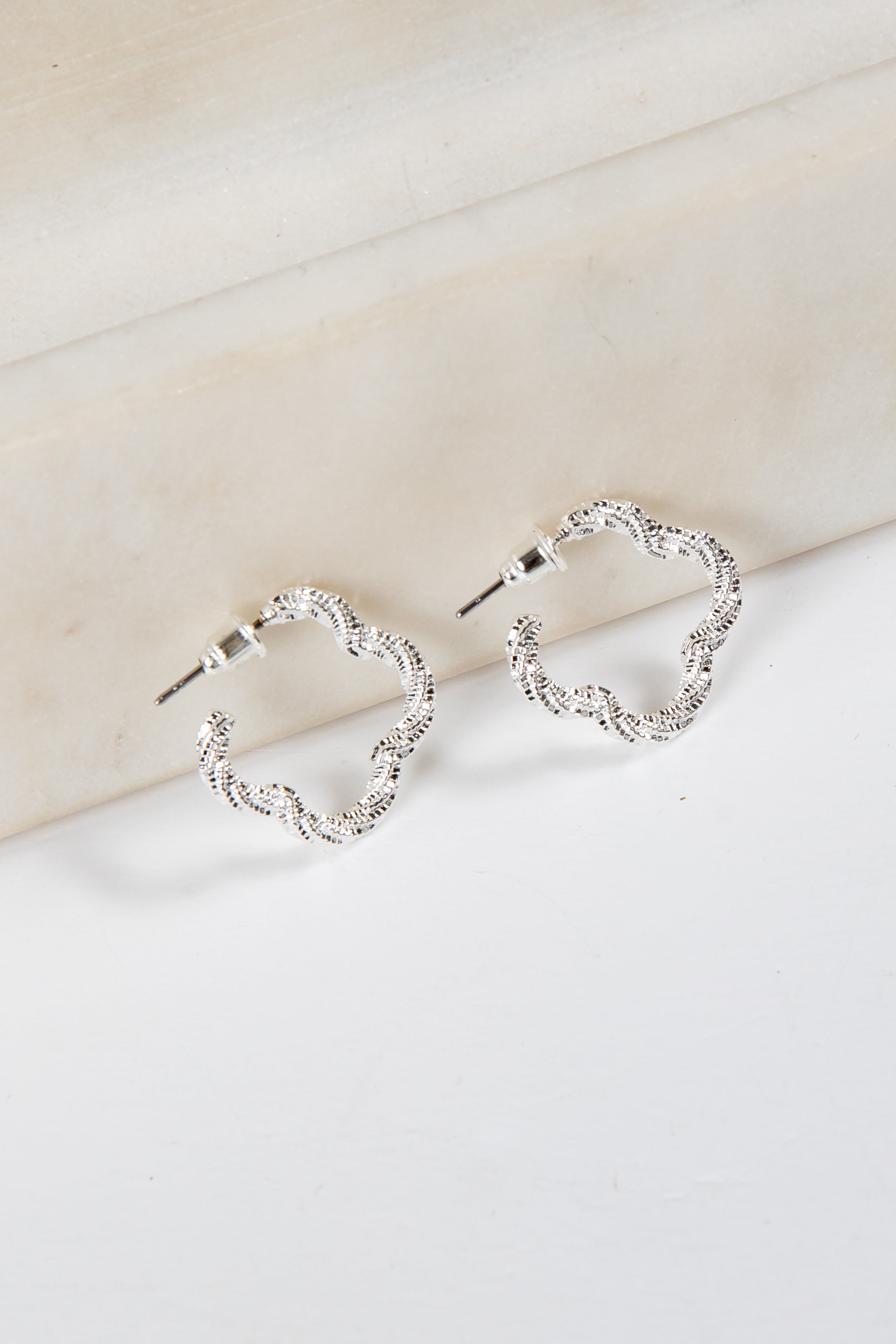 Pair of silver hoop earrings on a light background