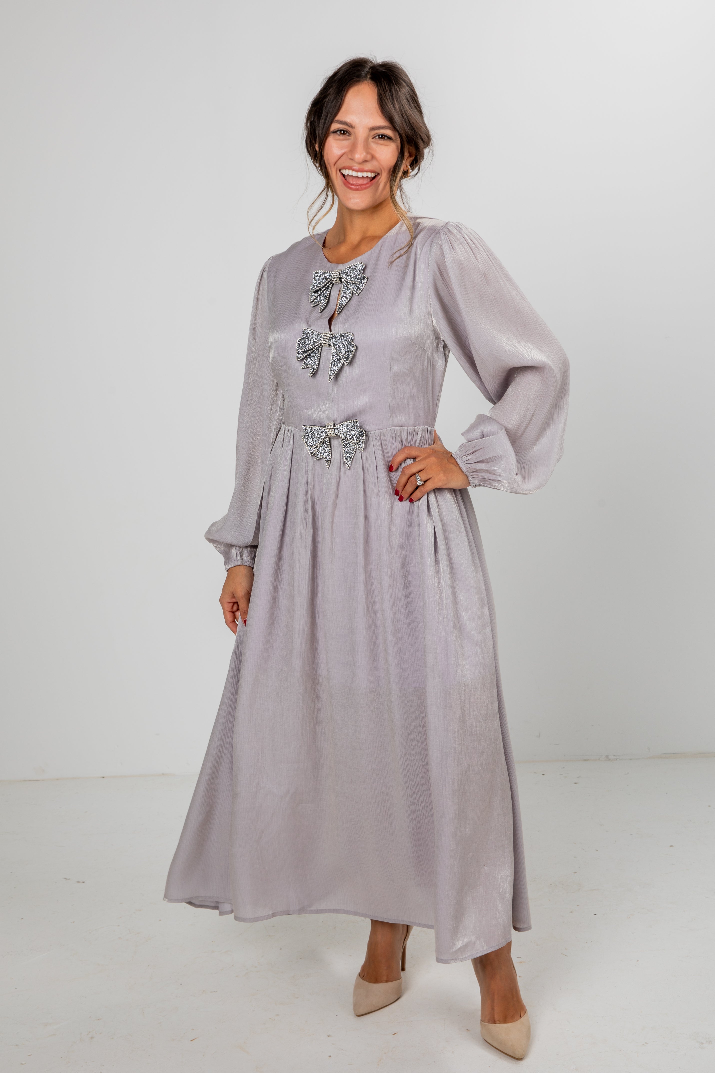 Woman wearing a light purple dress with decorative elements on a white background