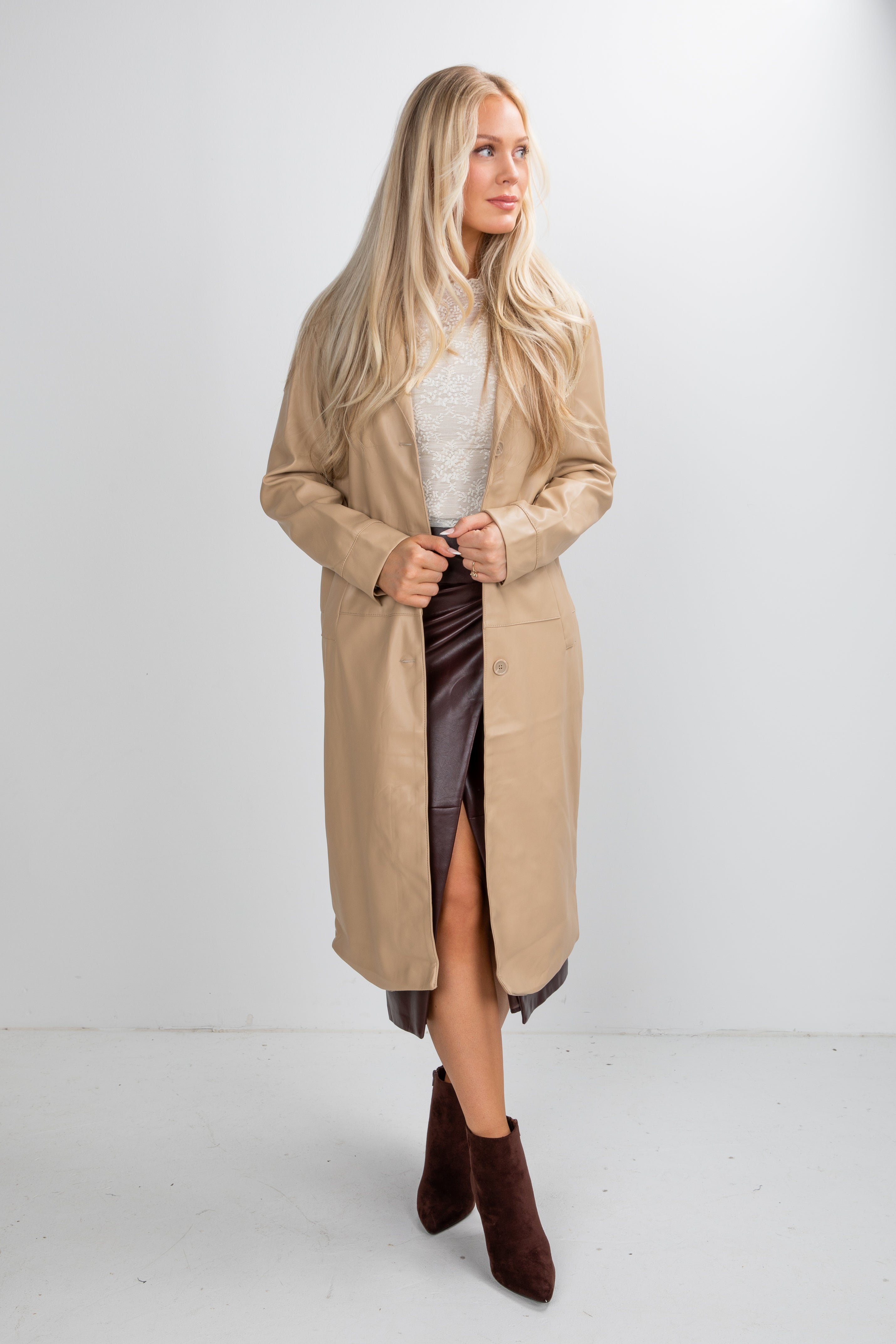 Woman wearing a beige trench coat on a white background