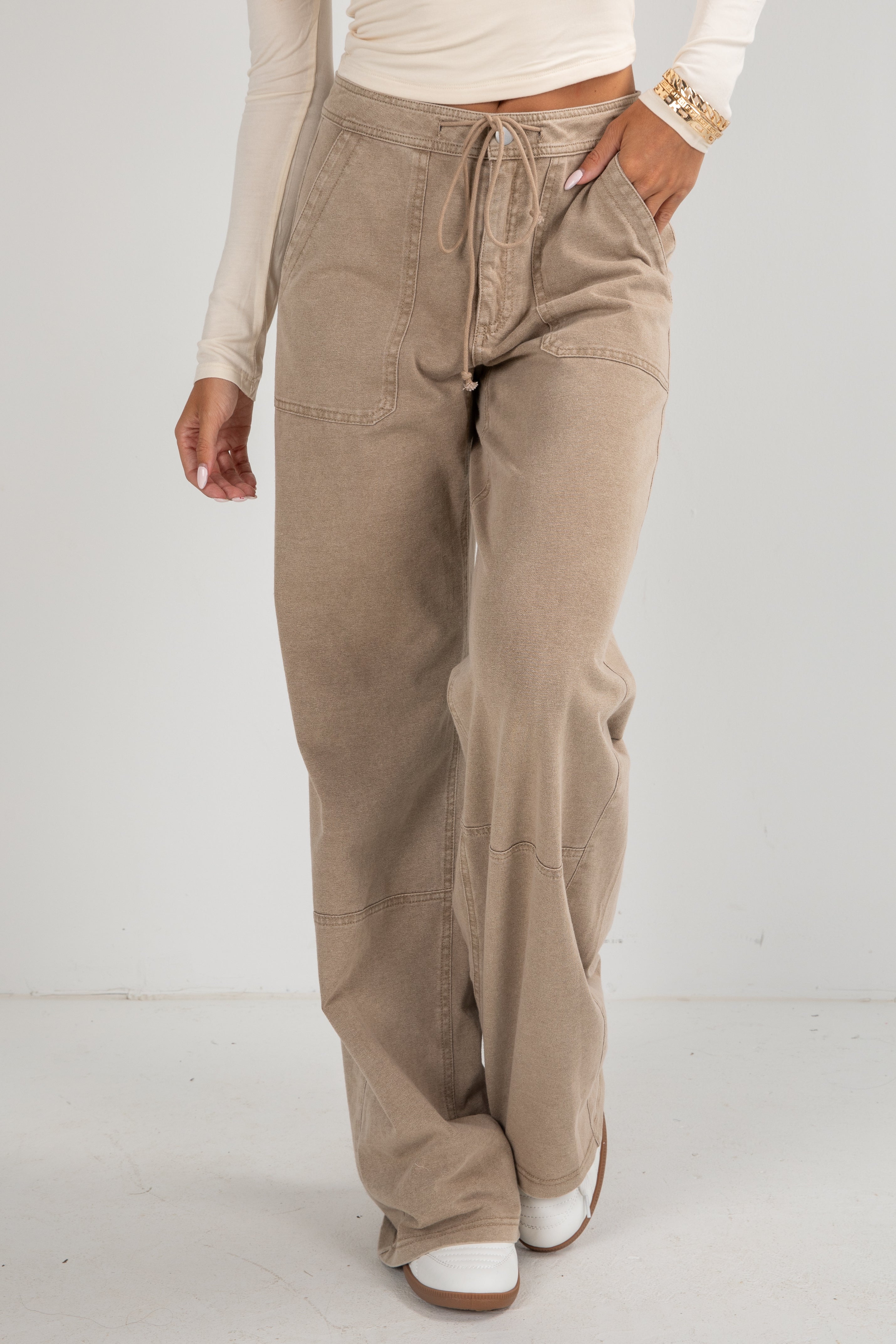 Beige pants worn by a person on a white background