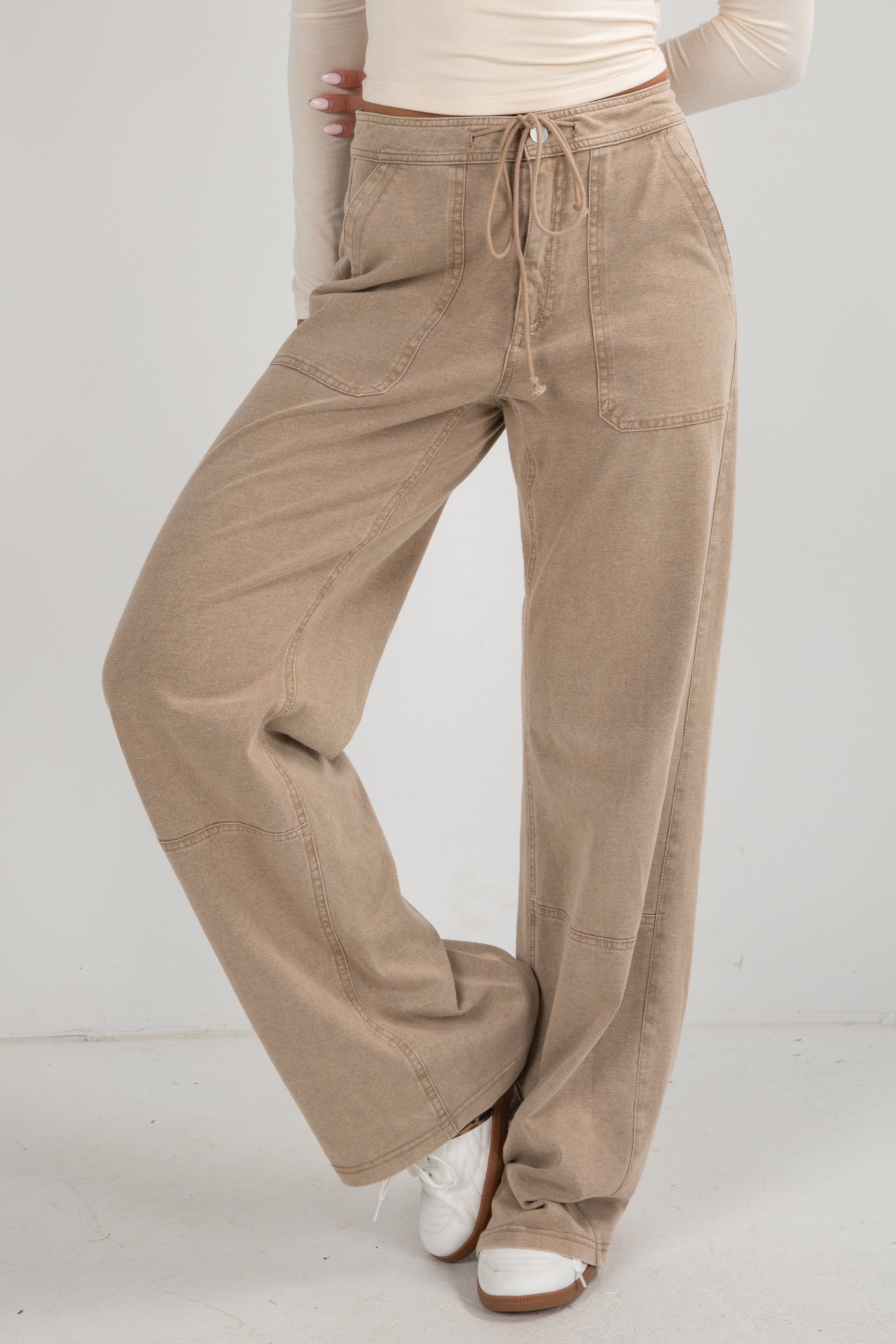 Beige wide-leg pants worn by a person on a white background