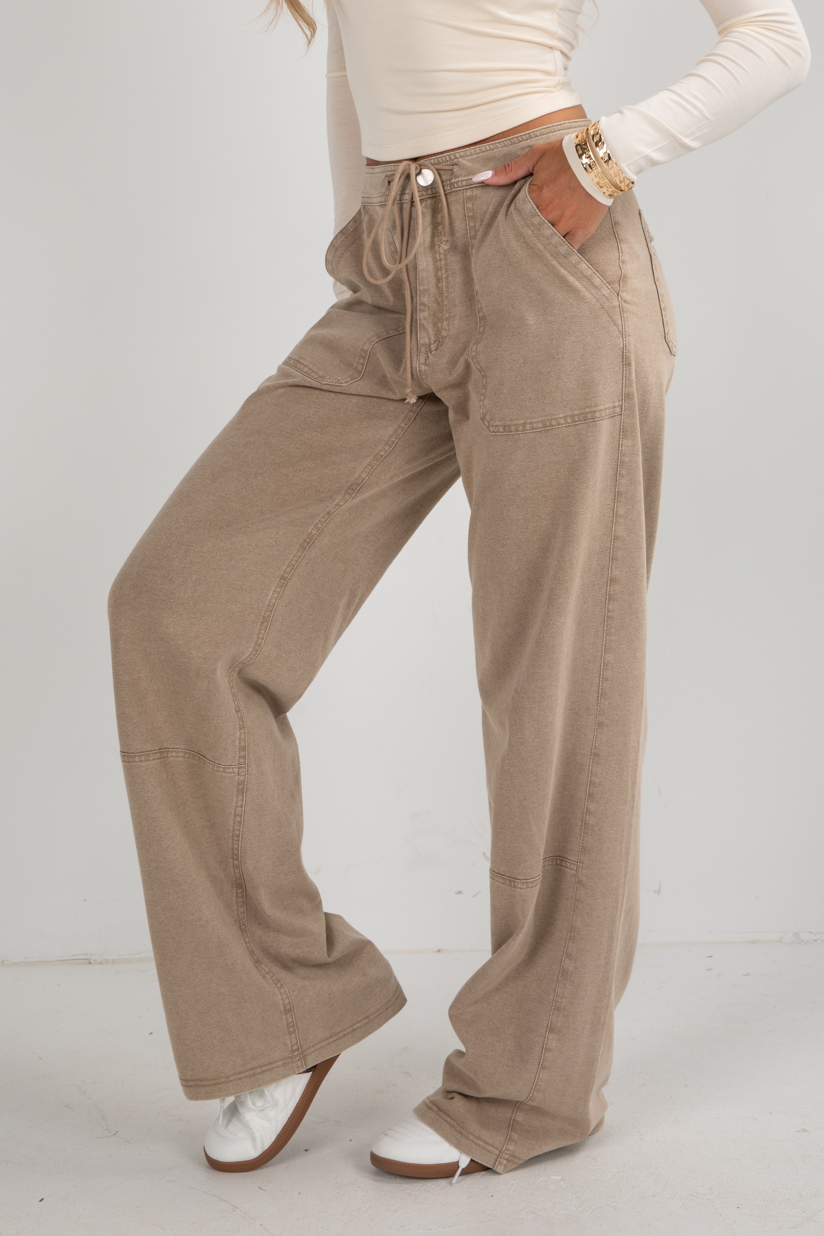 Person wearing beige corduroy pants on a white background