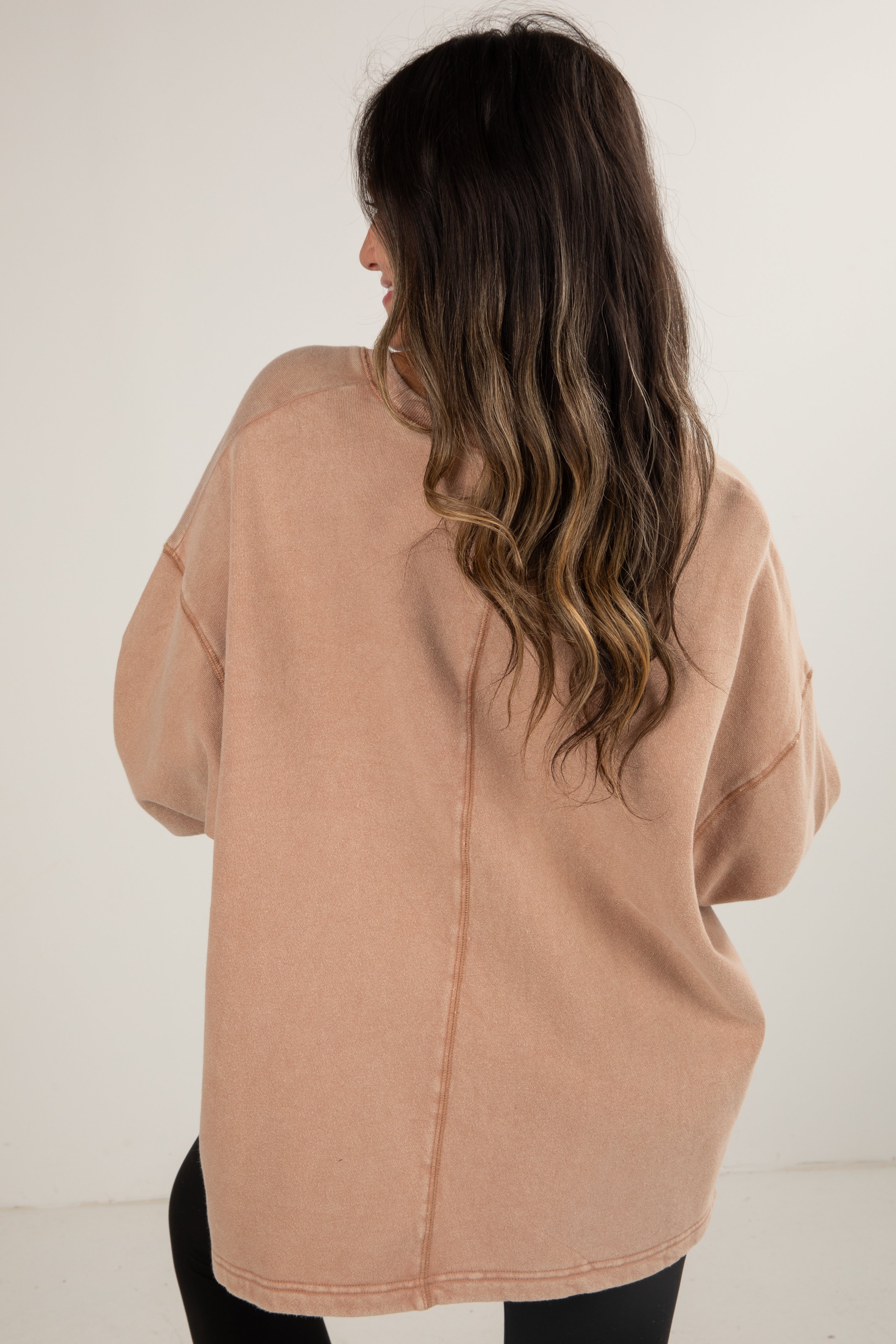 Woman wearing a beige coat against a white background