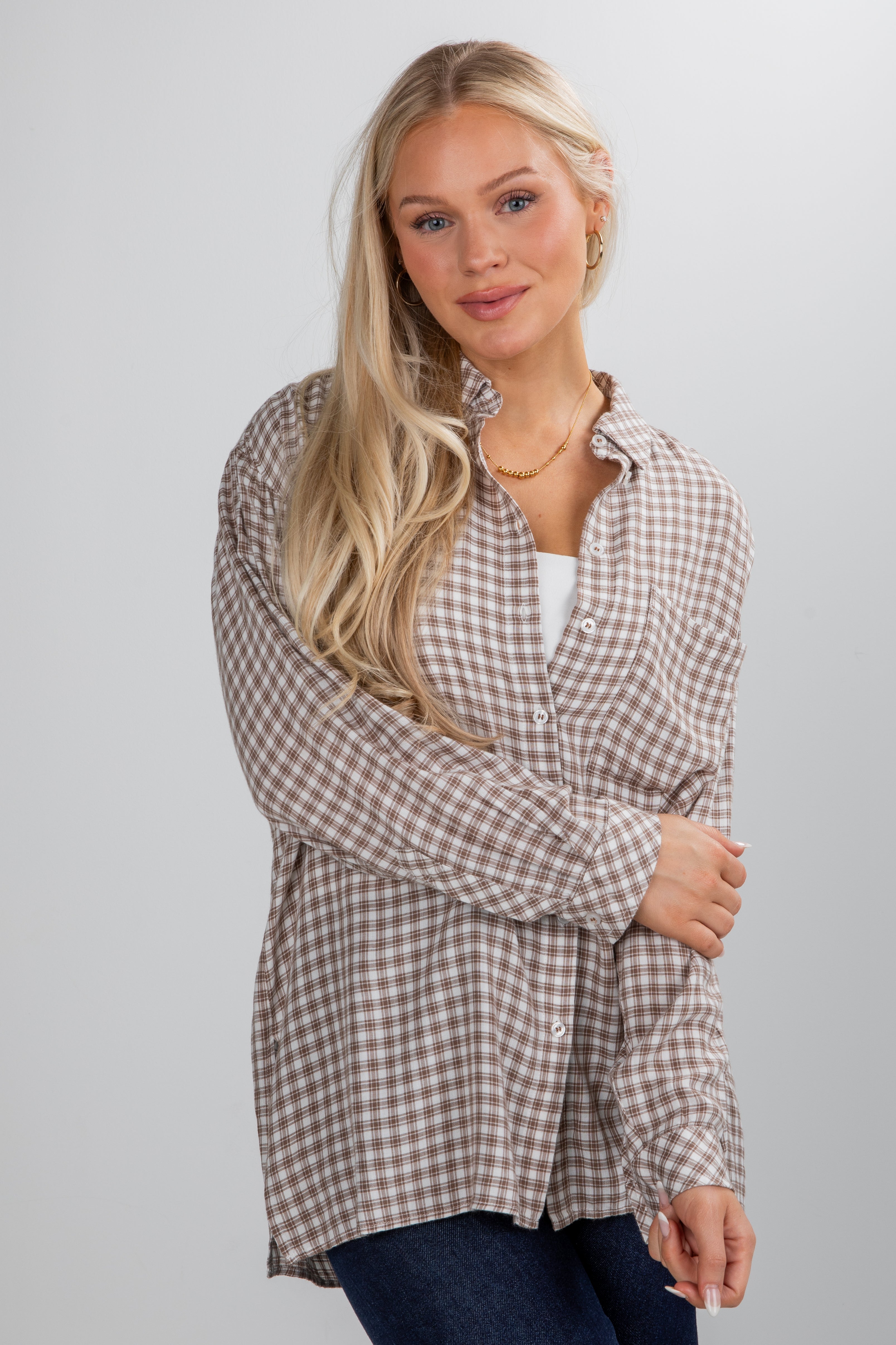 Woman wearing a plaid shirt against a plain background