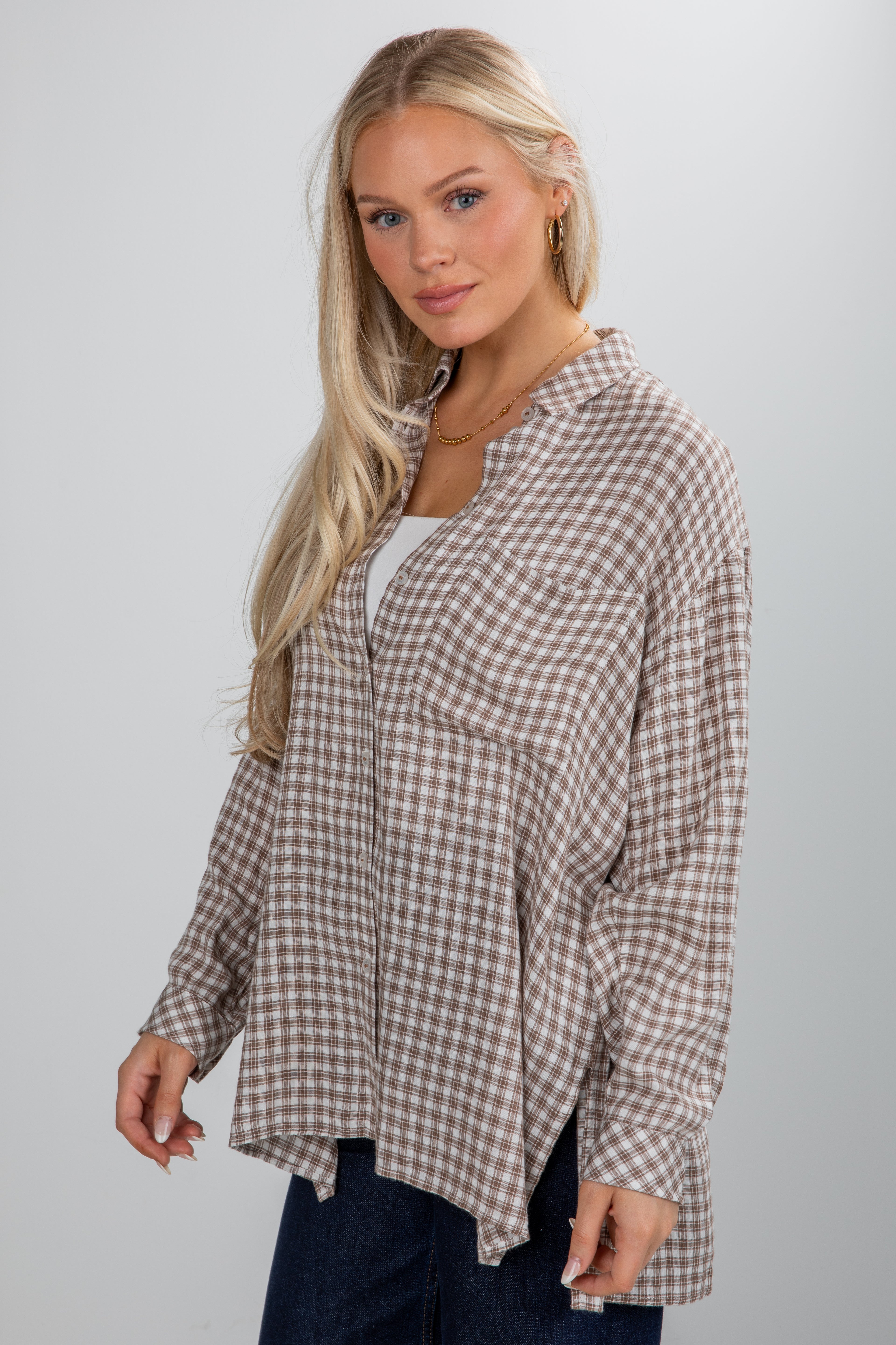 Woman wearing a plaid shirt against a plain background
