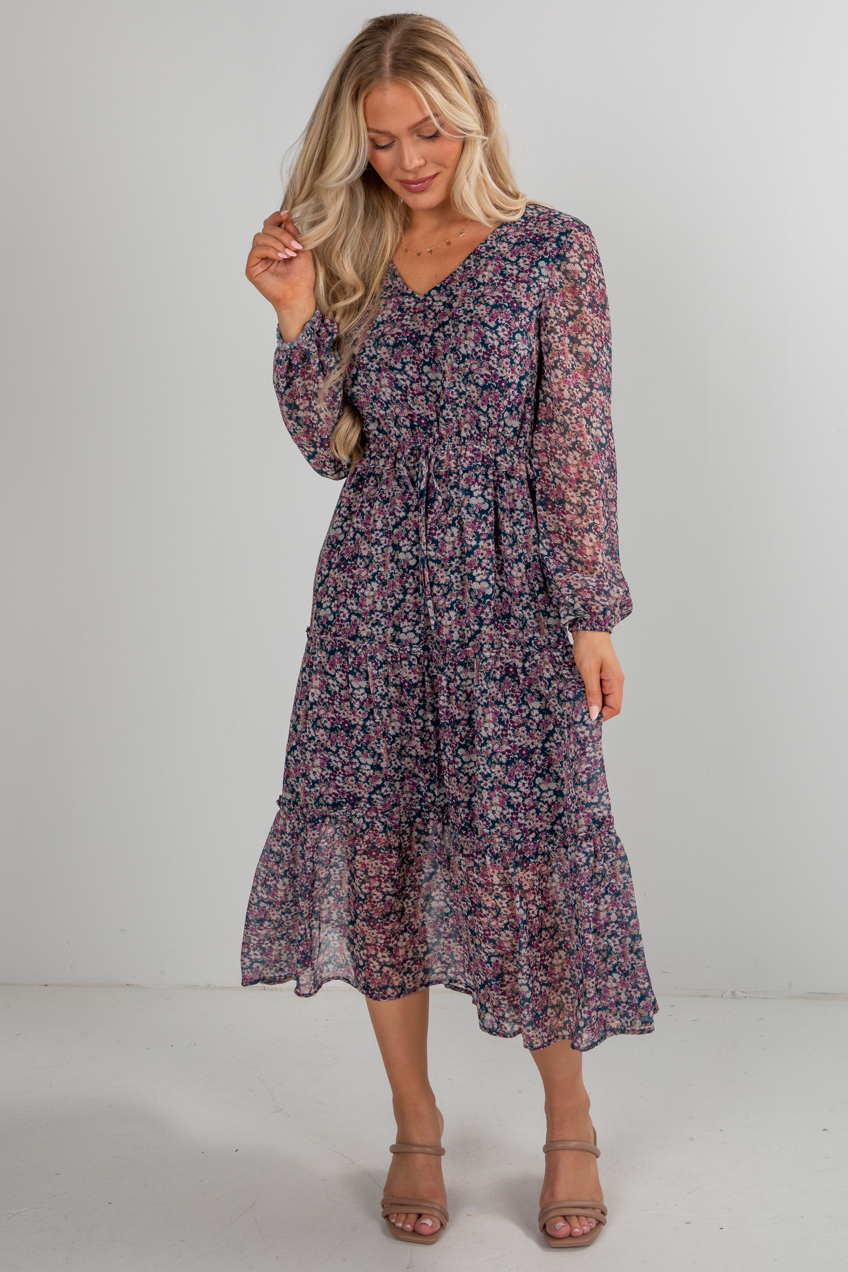 Woman wearing a floral dress against a plain background