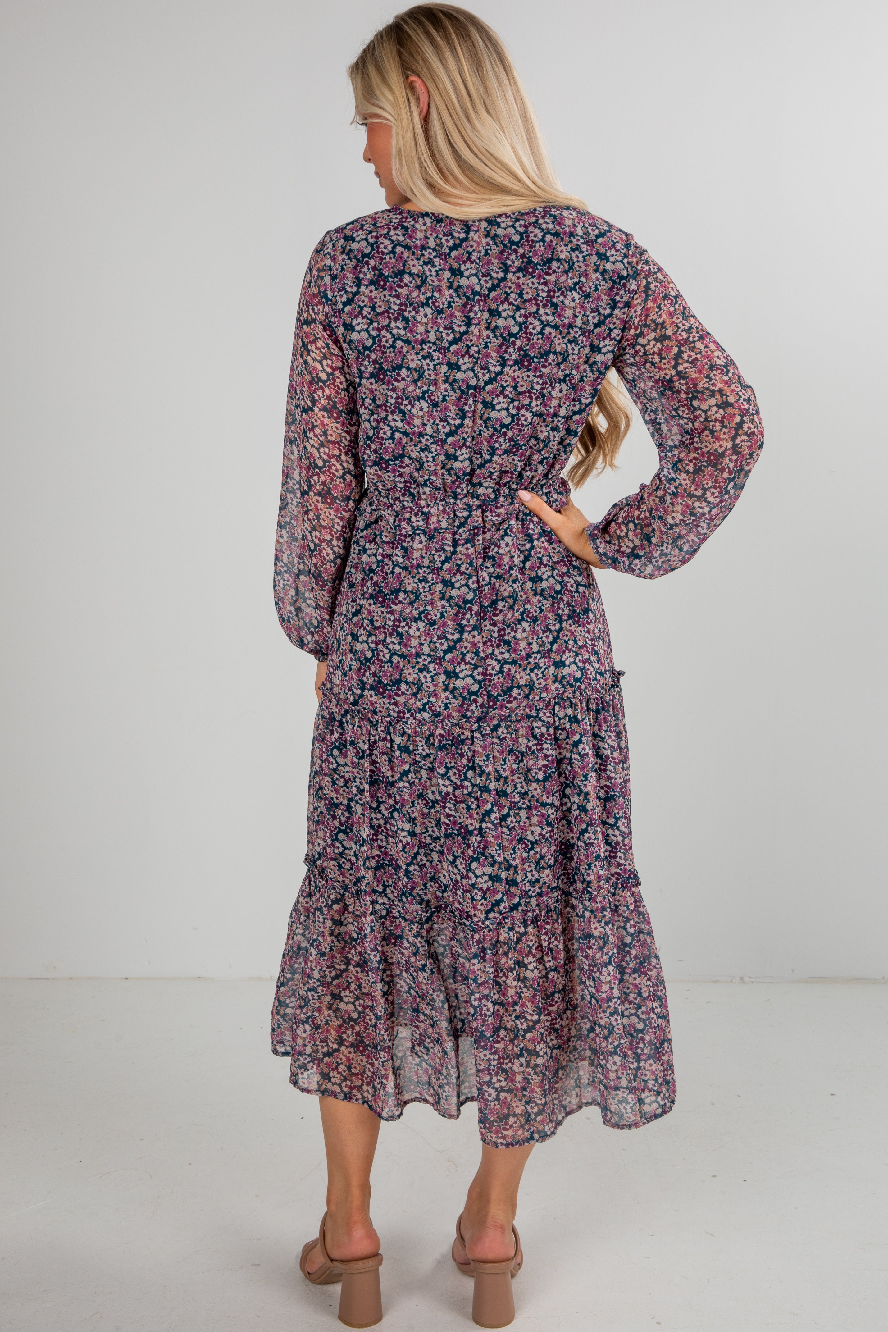 Woman wearing a floral dress with long sleeves on a white background
