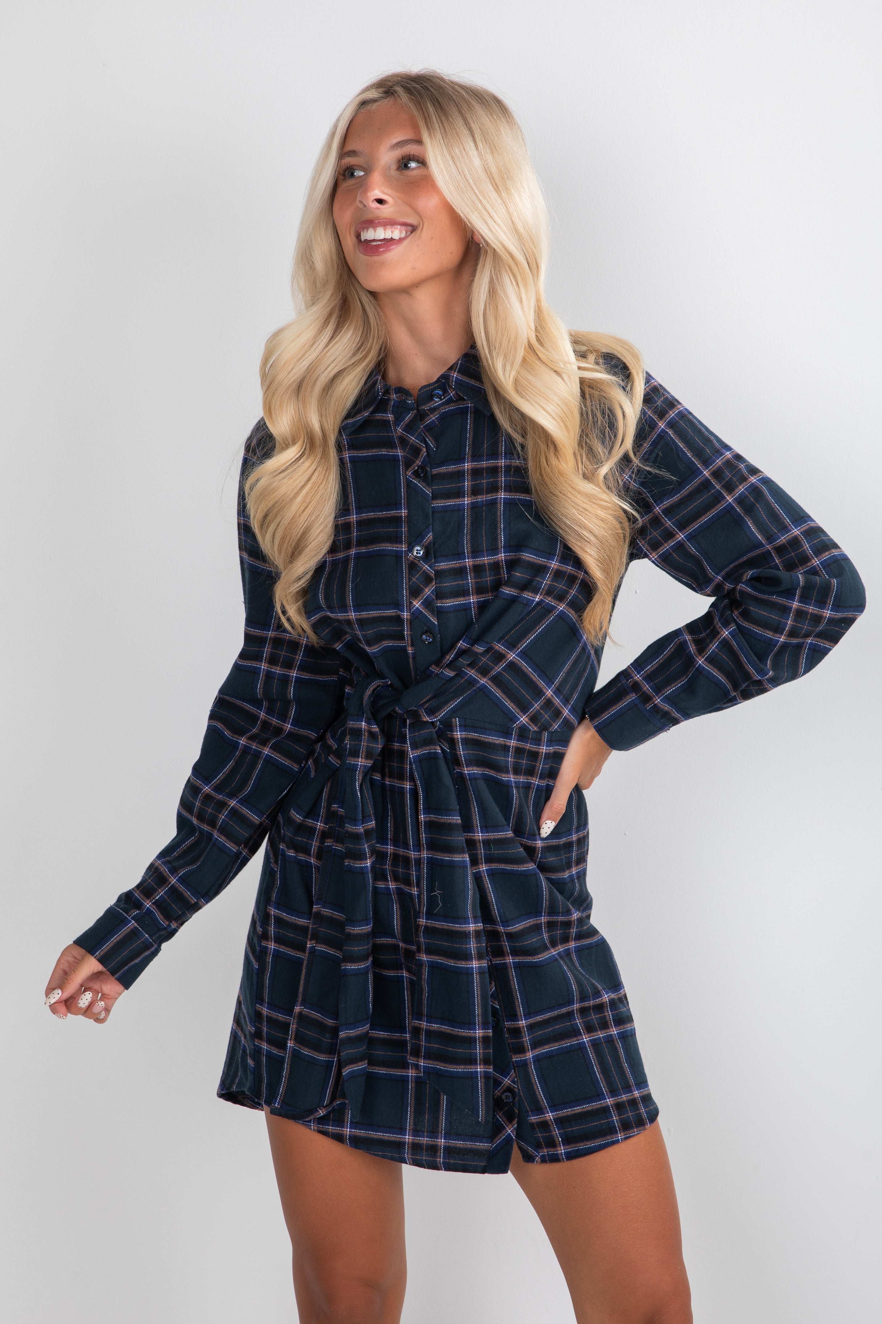 Woman wearing a navy plaid dress against a white background