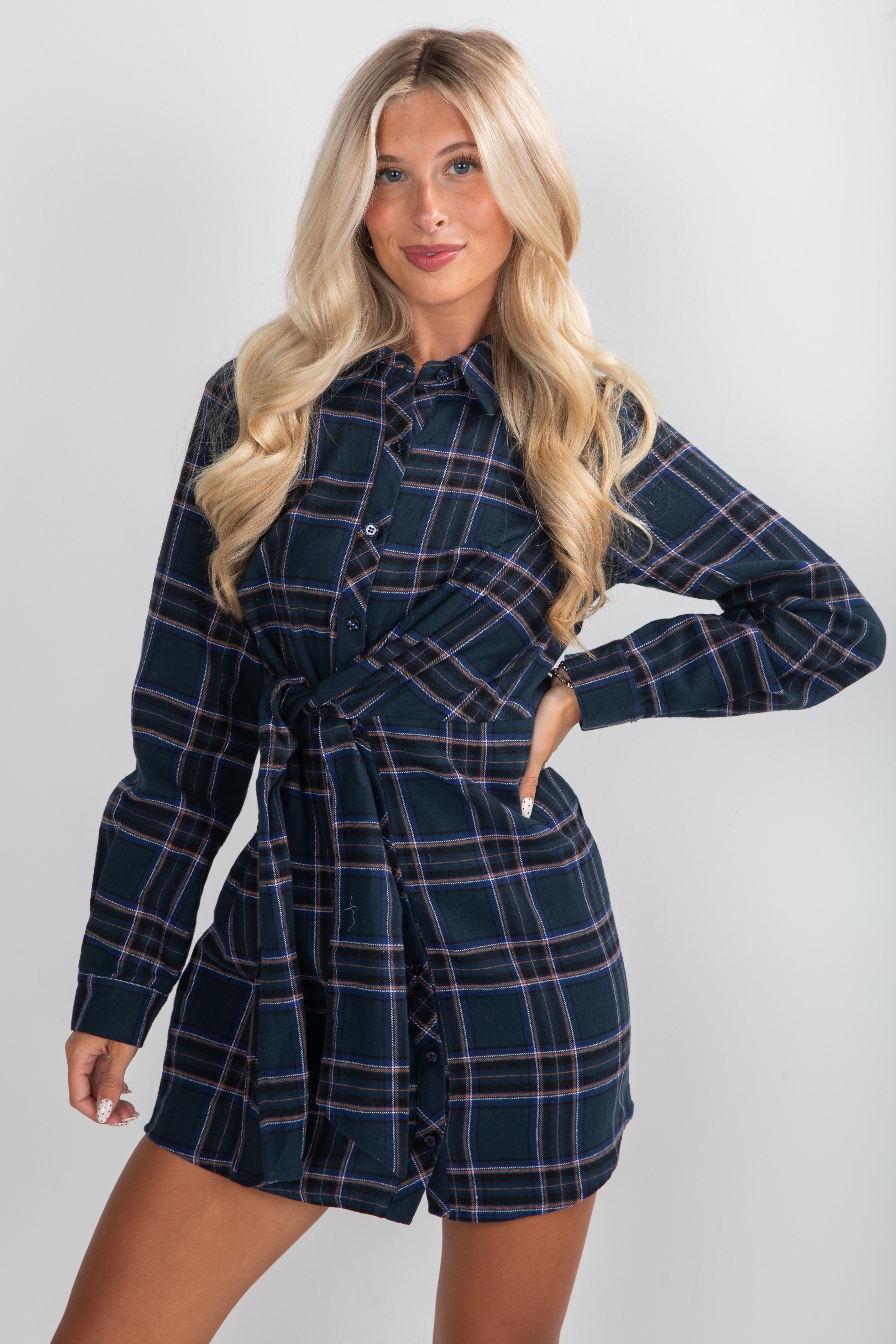 Woman wearing a plaid dress against a plain background