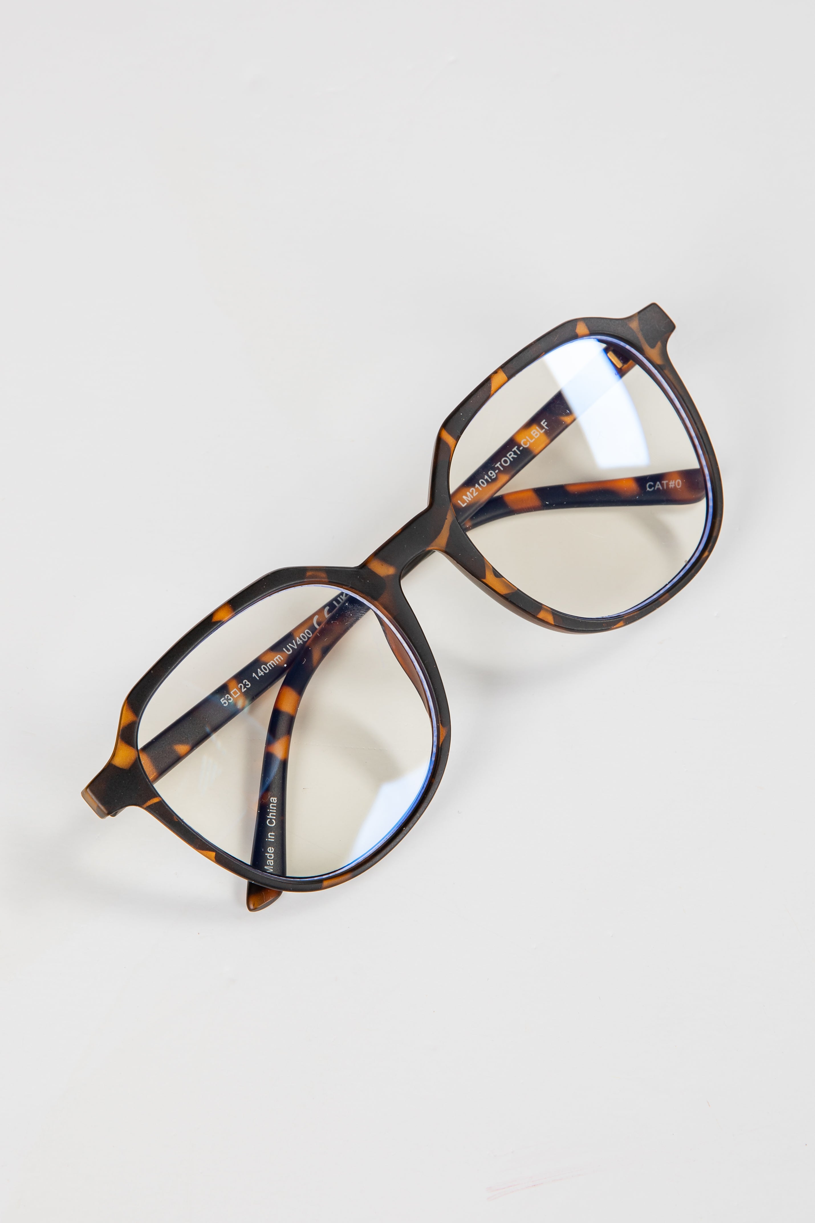 Tortoiseshell eyeglasses on a light gray background