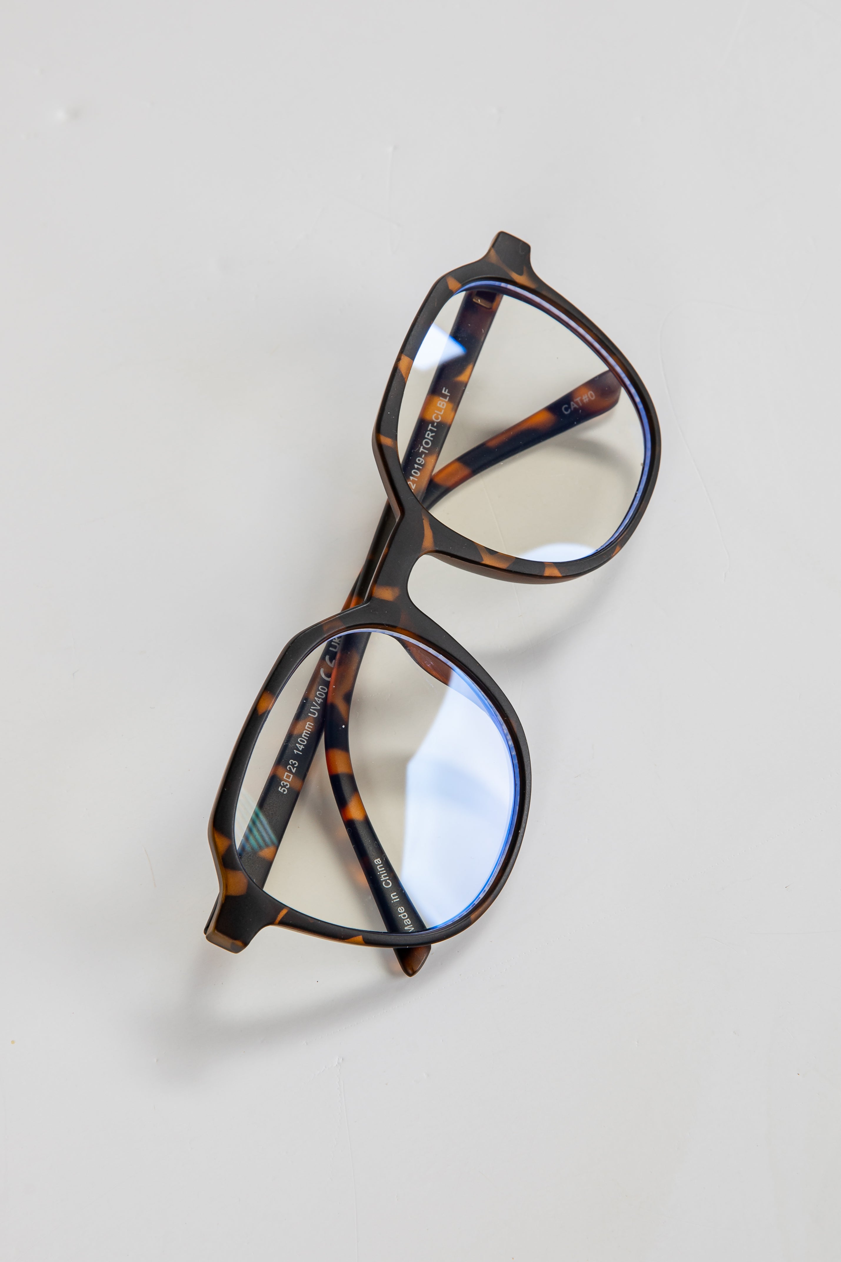 Tortoiseshell eyeglasses on a light gray background