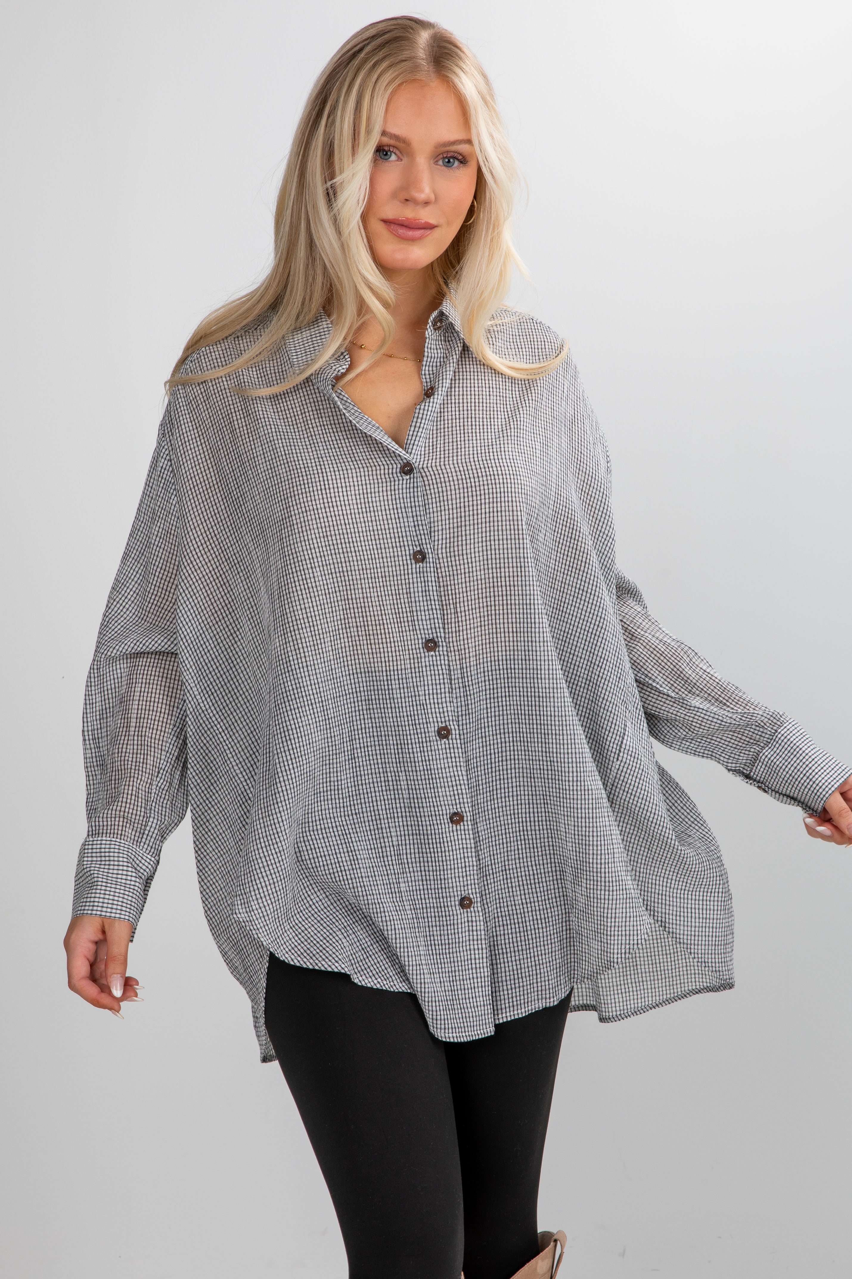 Woman wearing a checkered shirt with a plain background