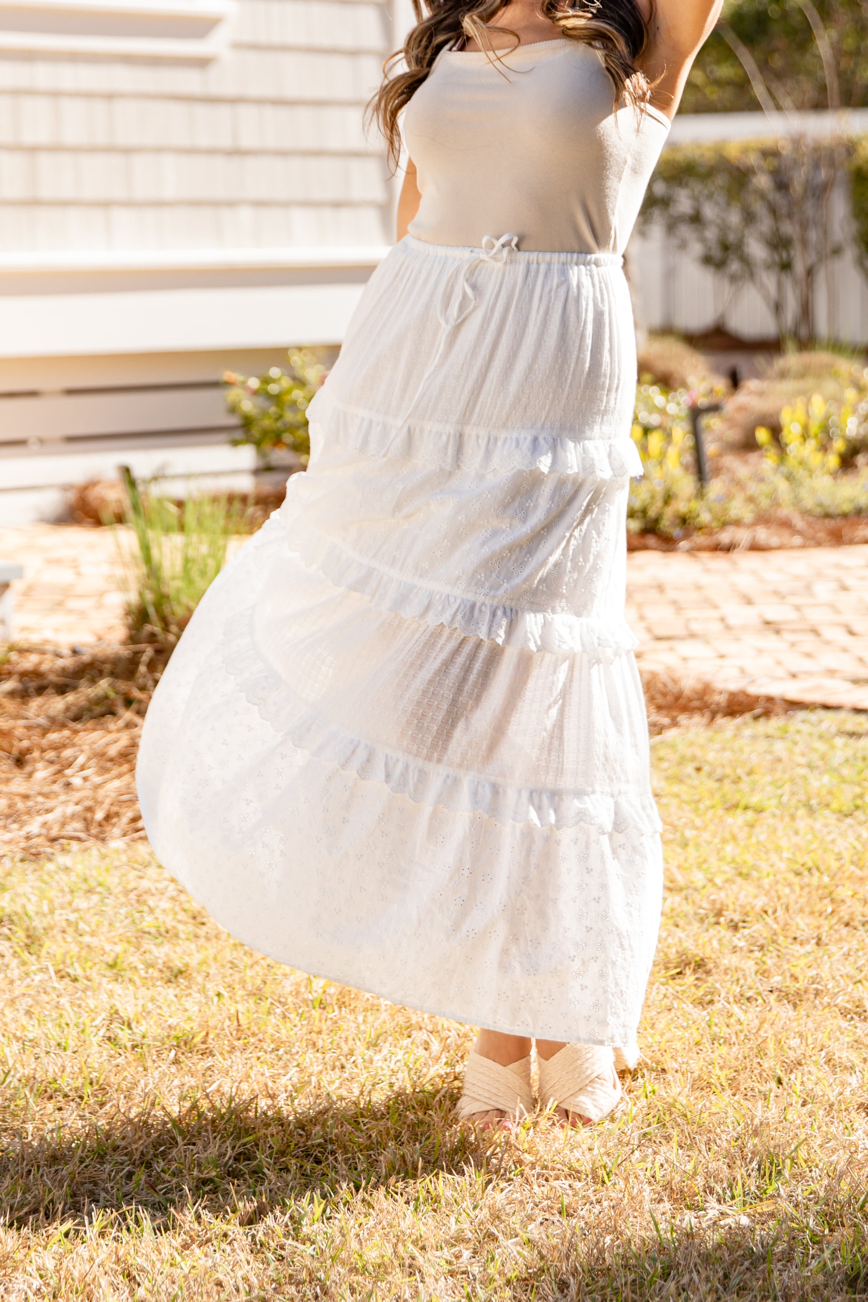 Woman wearing a white dress standing outdoors on grass