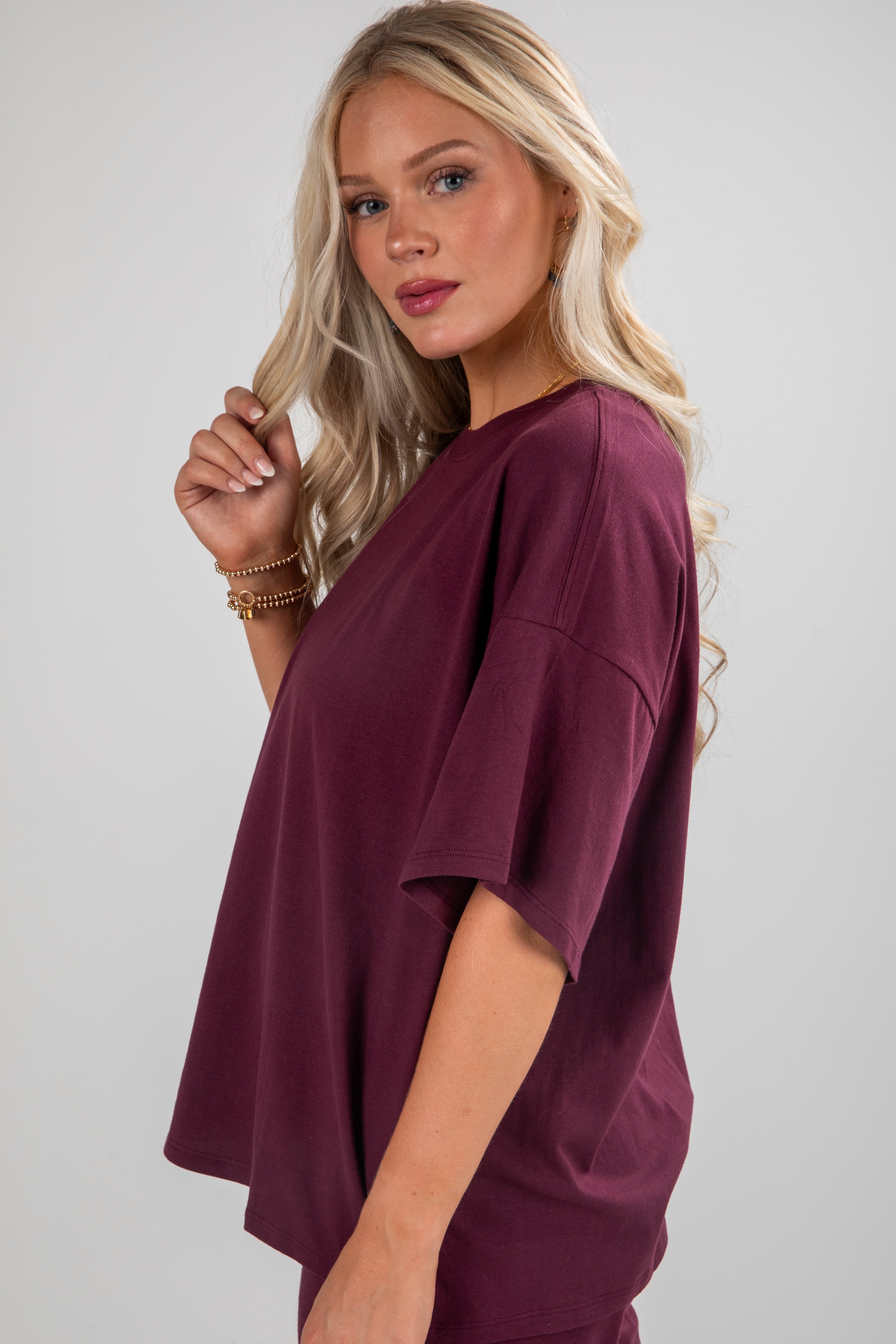 Woman wearing a burgundy top against a plain background