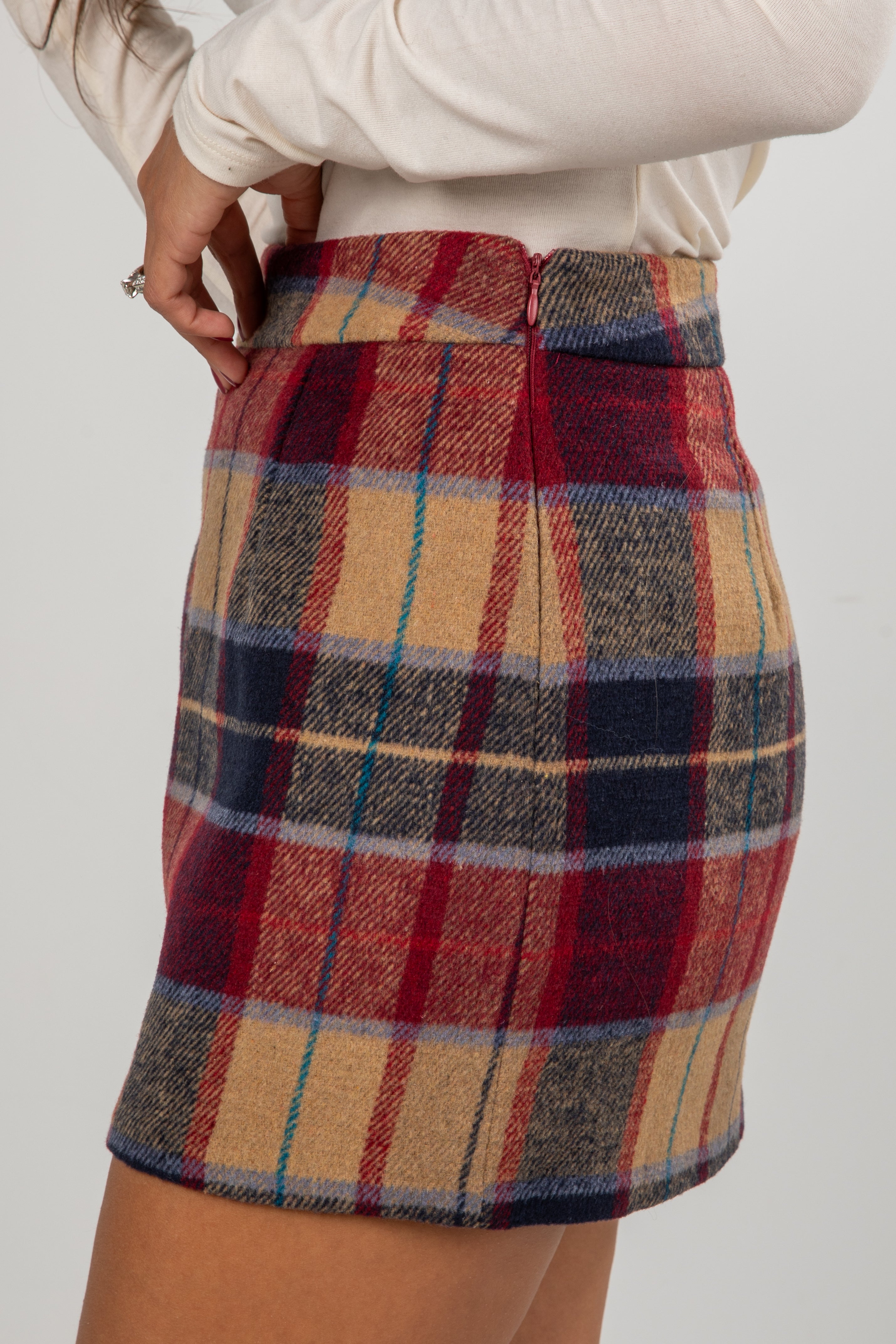 Plaid skirt worn by a person on a plain background