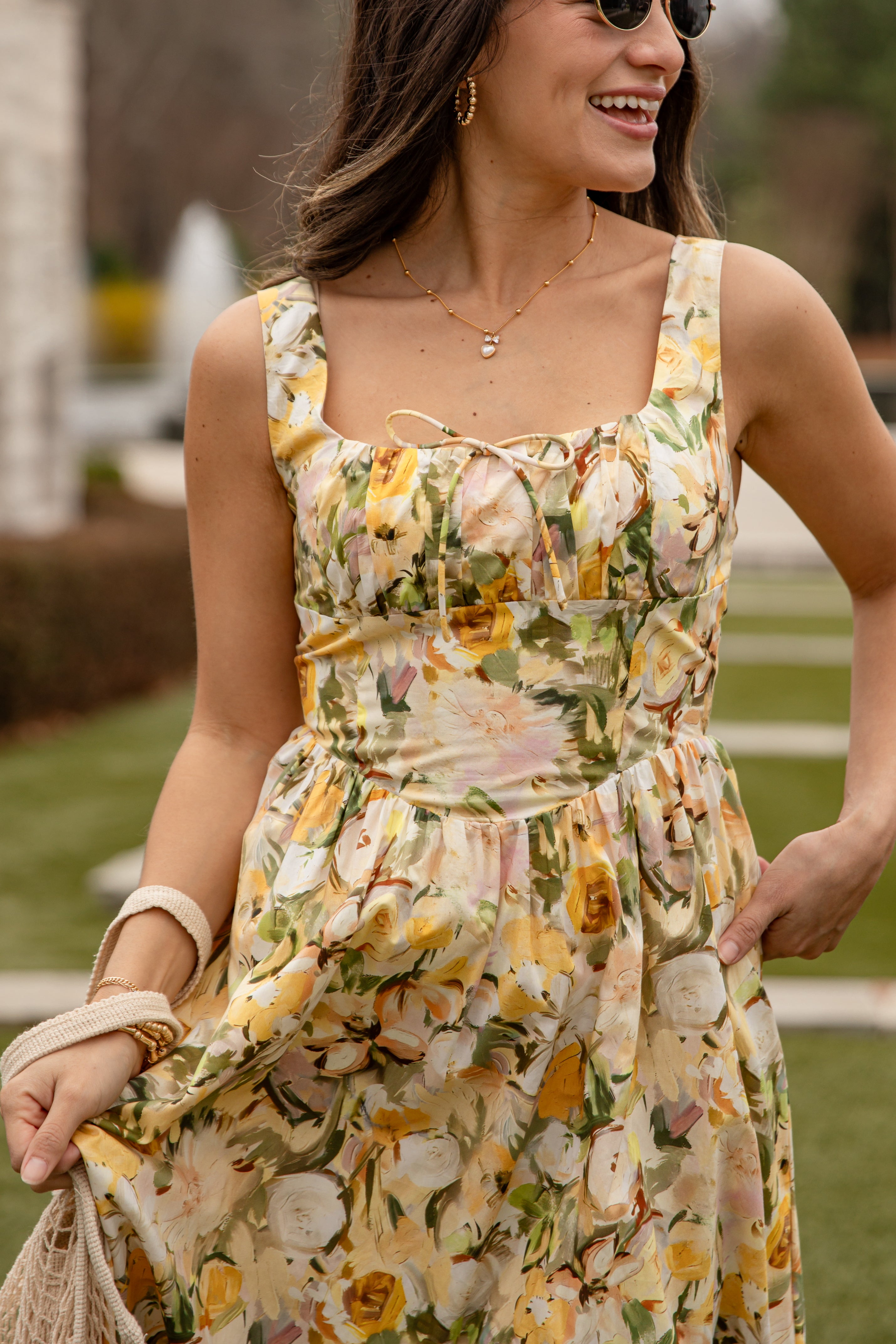 Woman wearing a floral dress with a blurred outdoor background