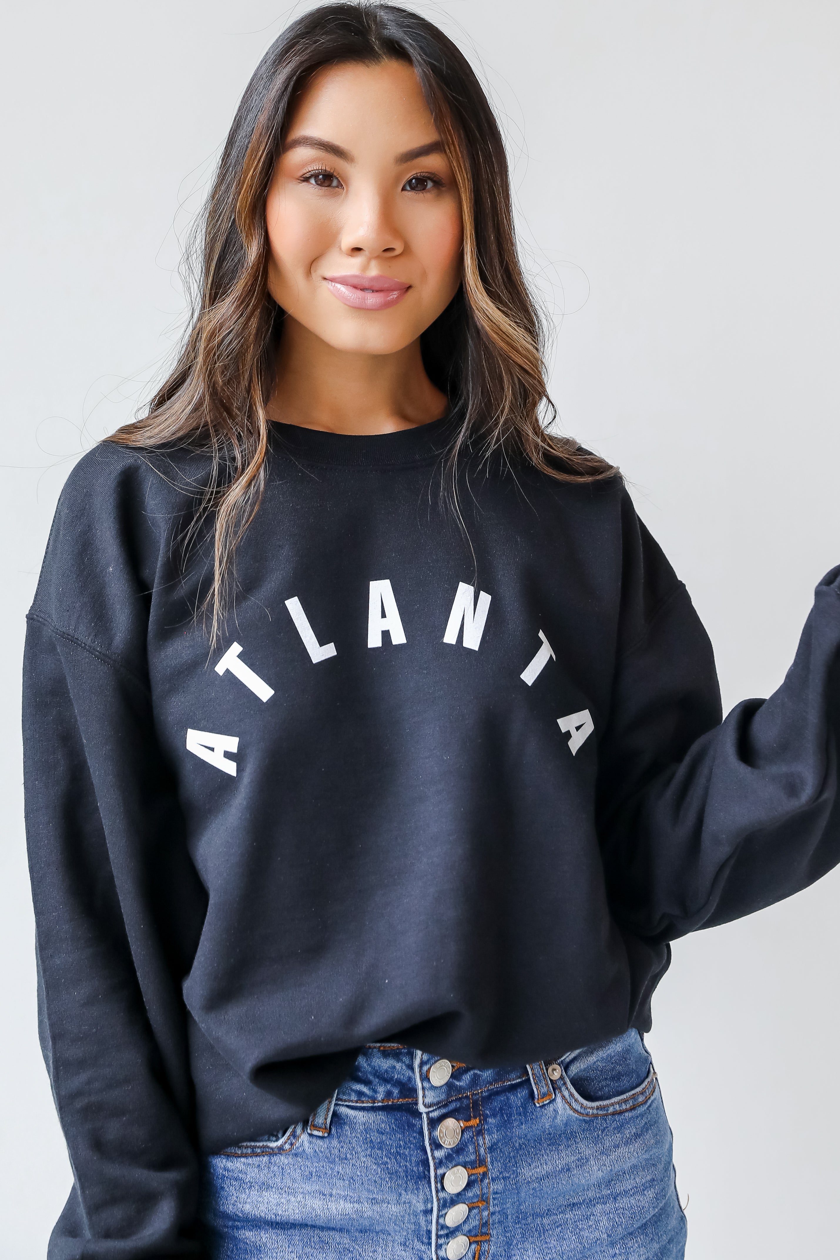 This comfy sweatshirt is designed with a soft and stretchy knit with a fleece interior. It features a crew neckline, long sleeves, a relaxed fit, and the word "Atlanta" on the front.