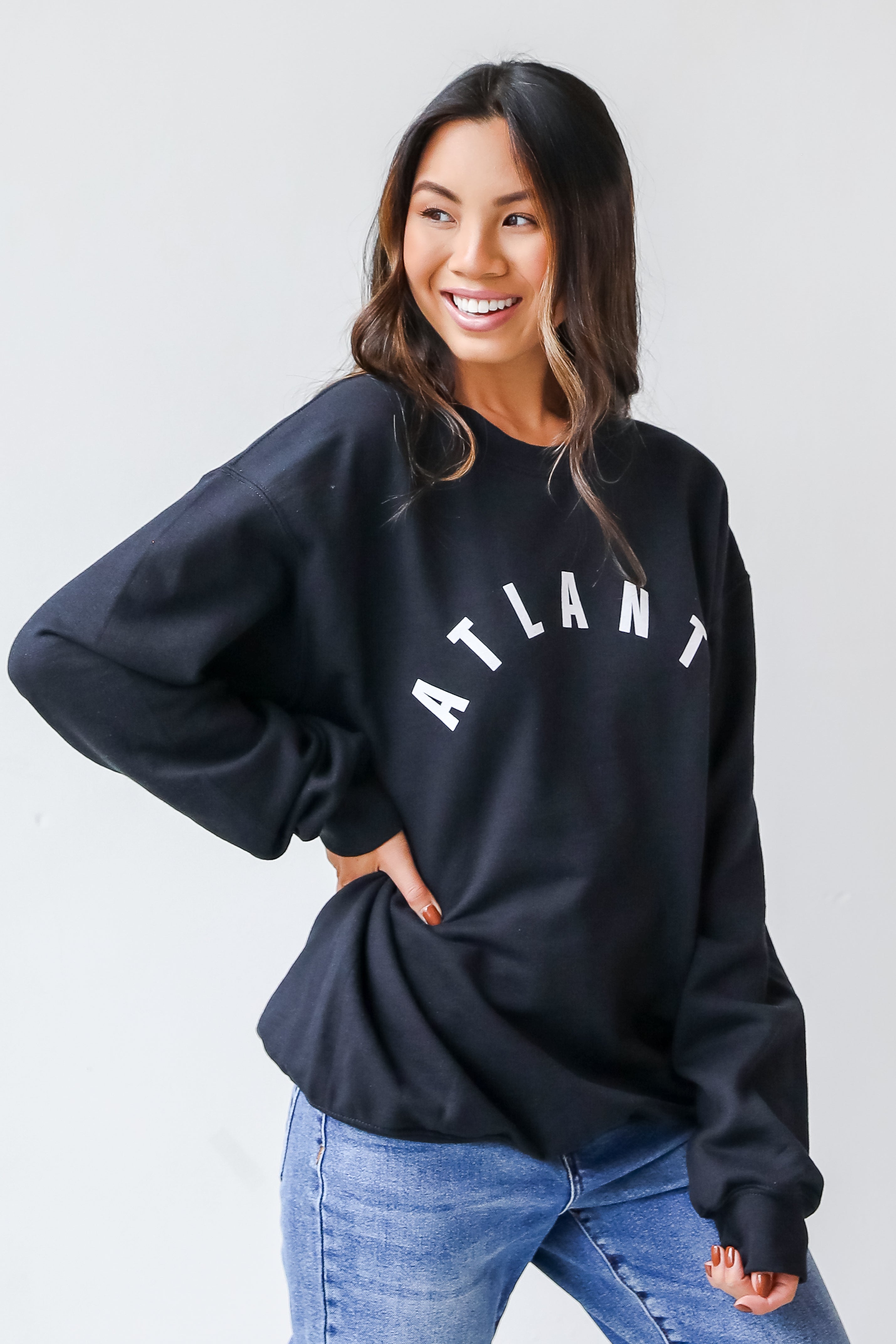 This comfy sweatshirt is designed with a soft and stretchy knit with a fleece interior. It features a crew neckline, long sleeves, a relaxed fit, and the word "Atlanta" on the front.