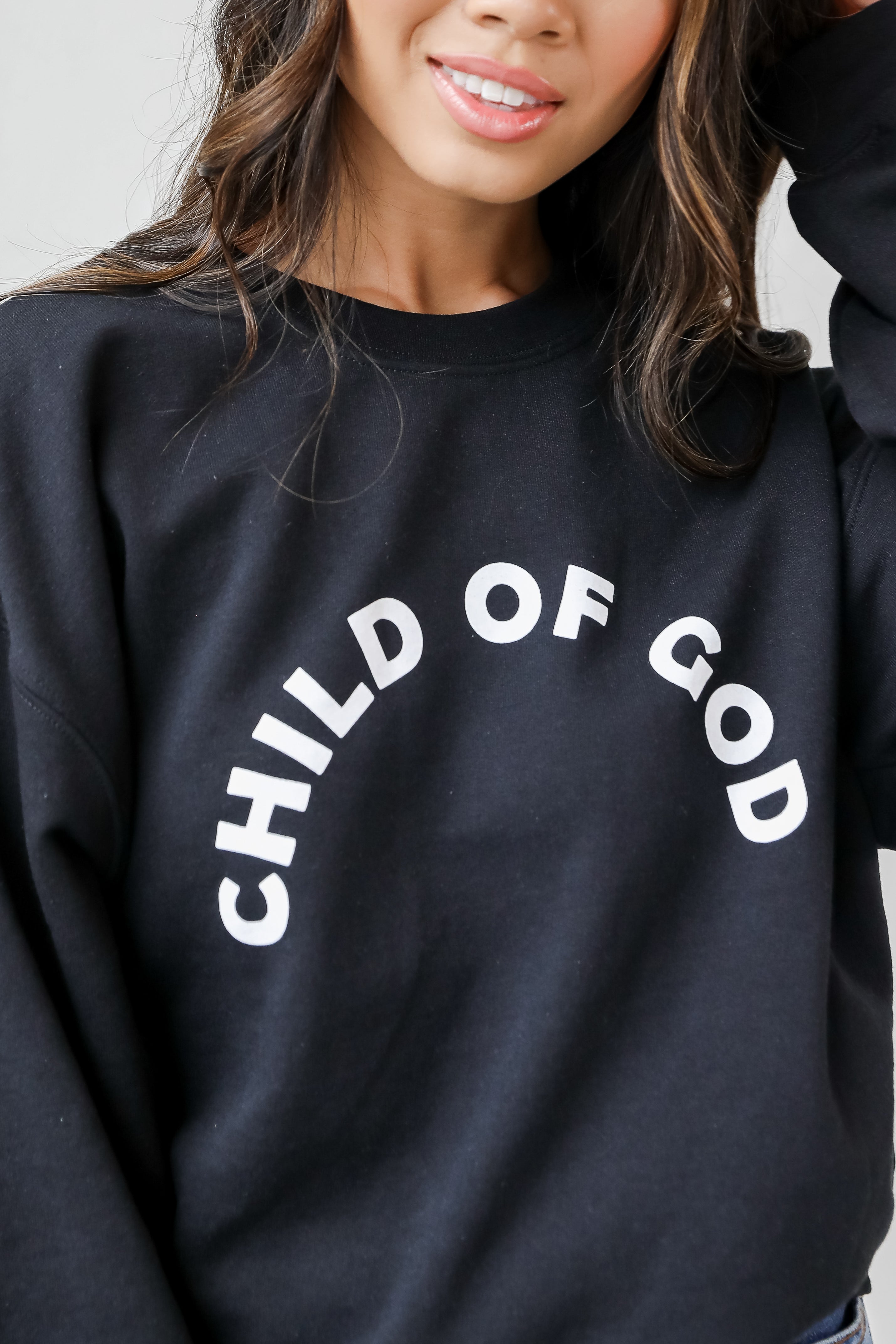 This comfy sweatshirt is designed with a soft and stretchy knit with a fleece interior. It features a crew neckline, long sleeves, a relaxed fit, and the words "Child Of God" on the front.