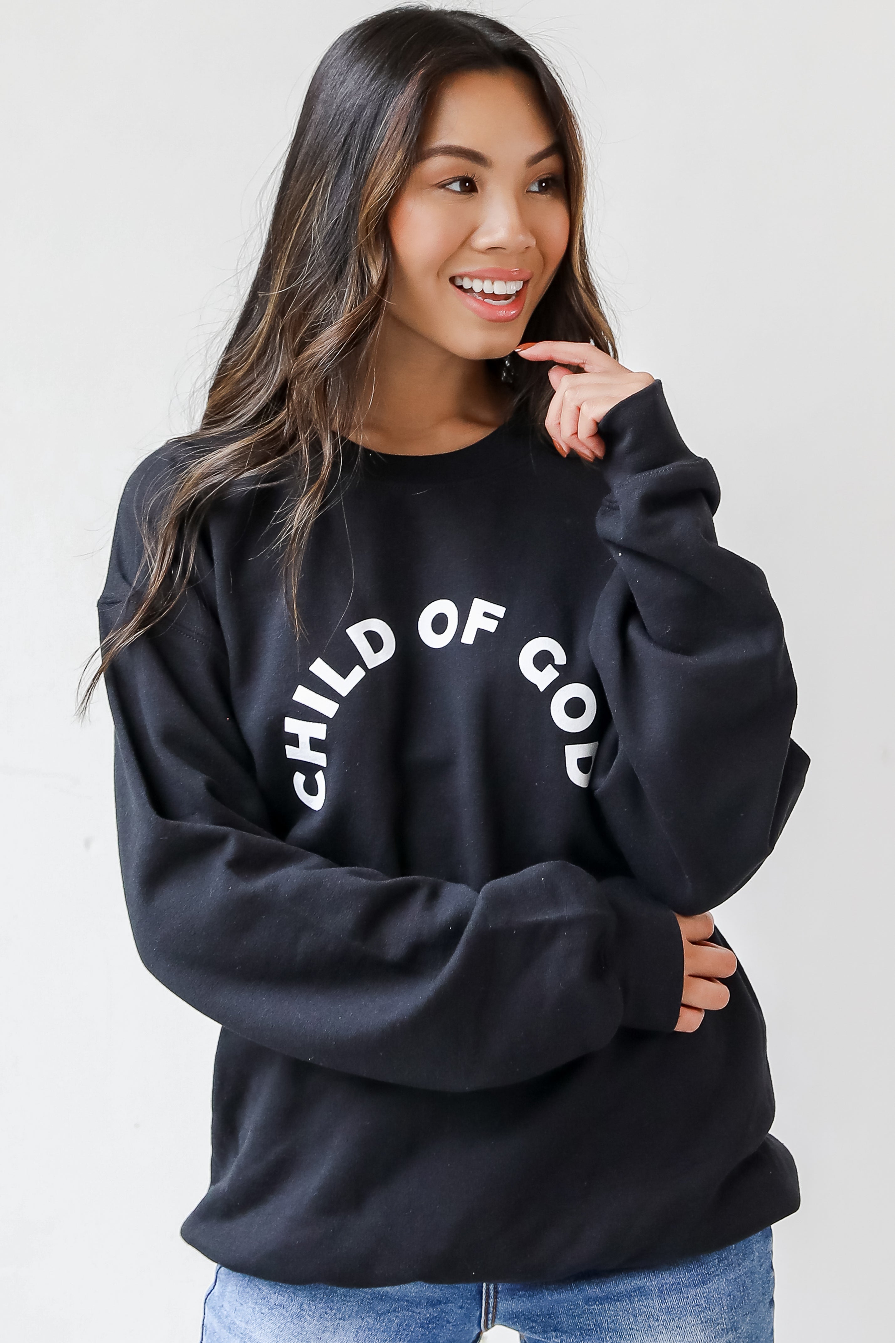 This comfy sweatshirt is designed with a soft and stretchy knit with a fleece interior. It features a crew neckline, long sleeves, a relaxed fit, and the words "Child Of God" on the front.