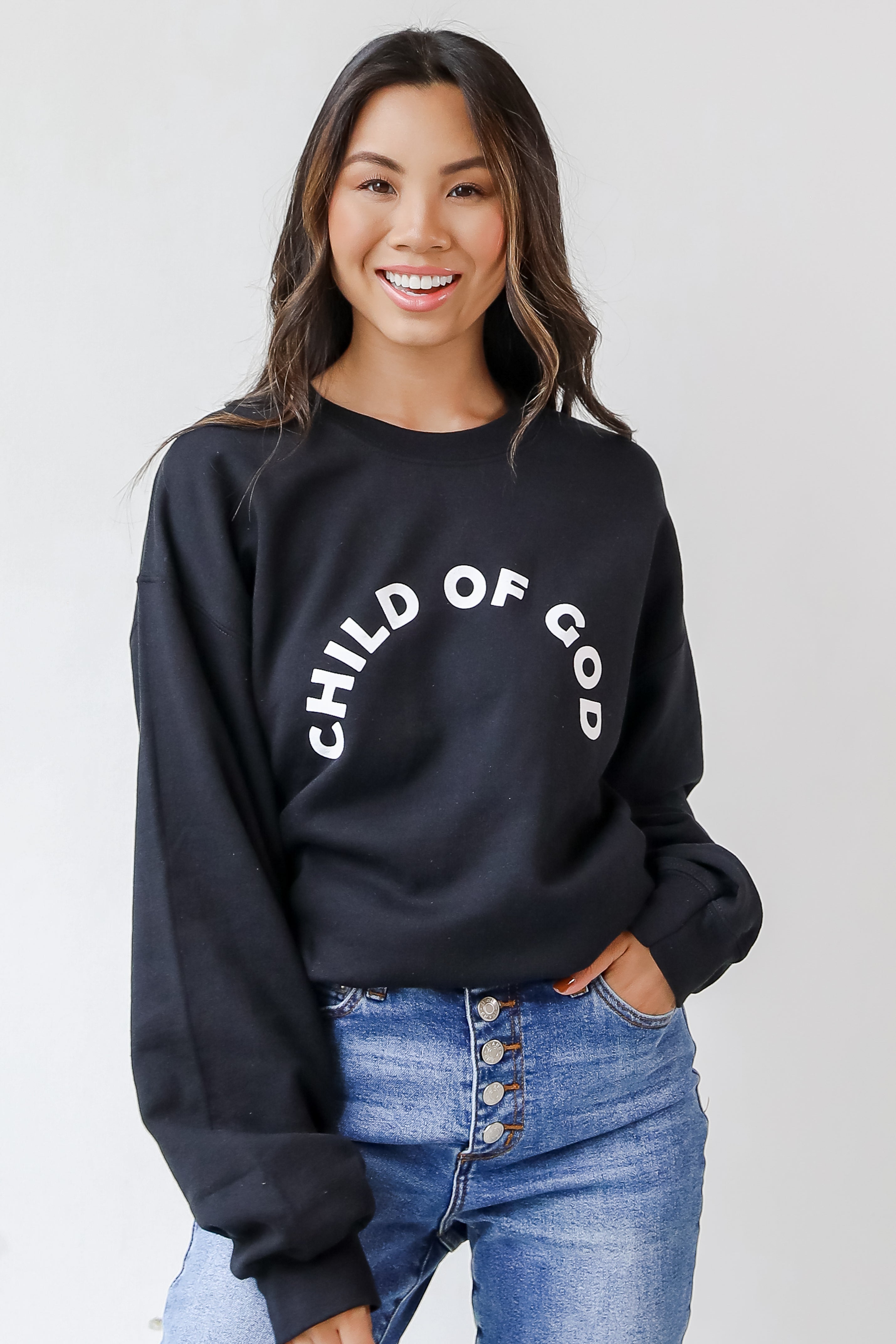 This comfy sweatshirt is designed with a soft and stretchy knit with a fleece interior. It features a crew neckline, long sleeves, a relaxed fit, and the words "Child Of God" on the front.
