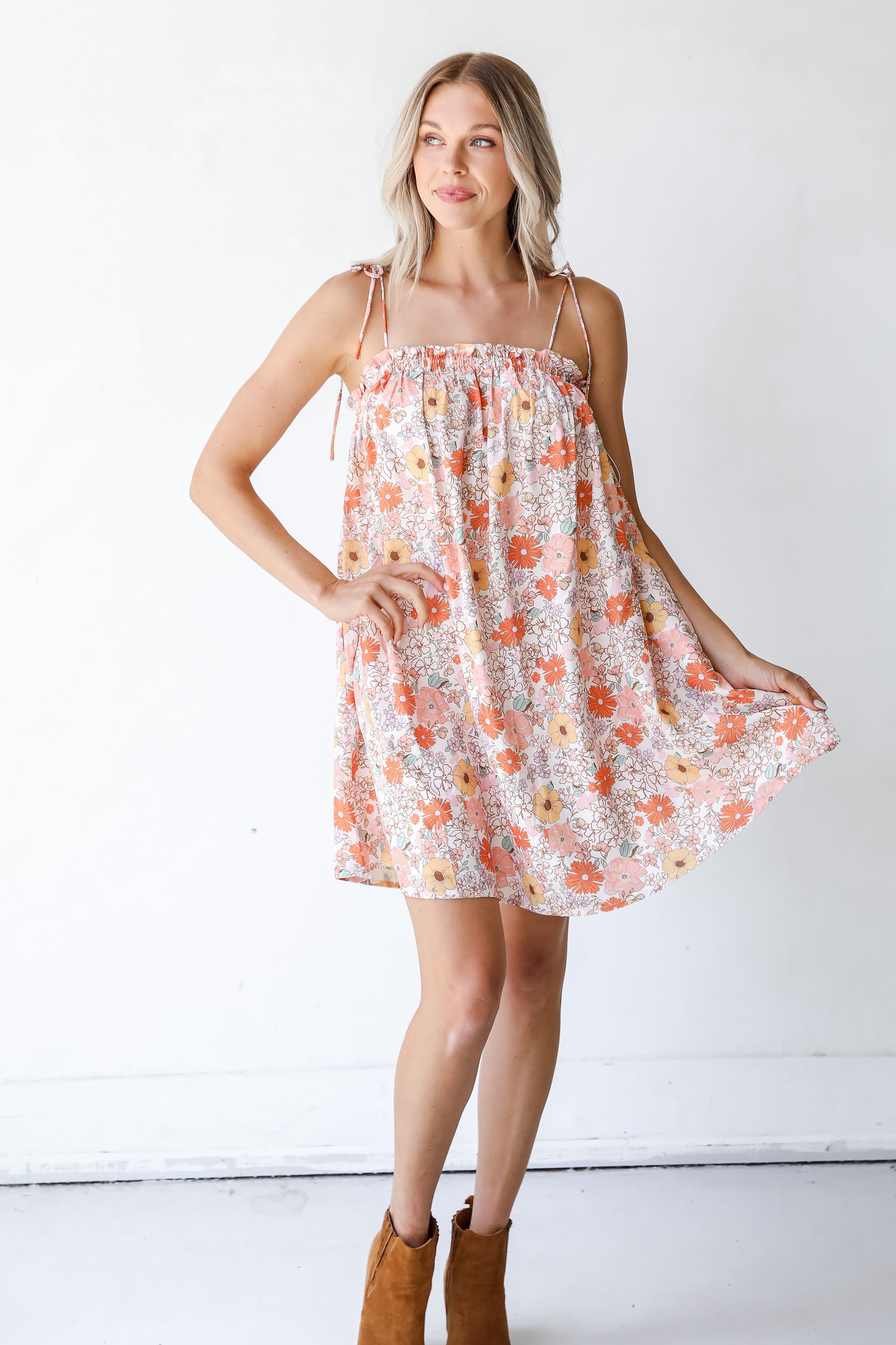 model wearing a Floral Mini Dress with tan booties