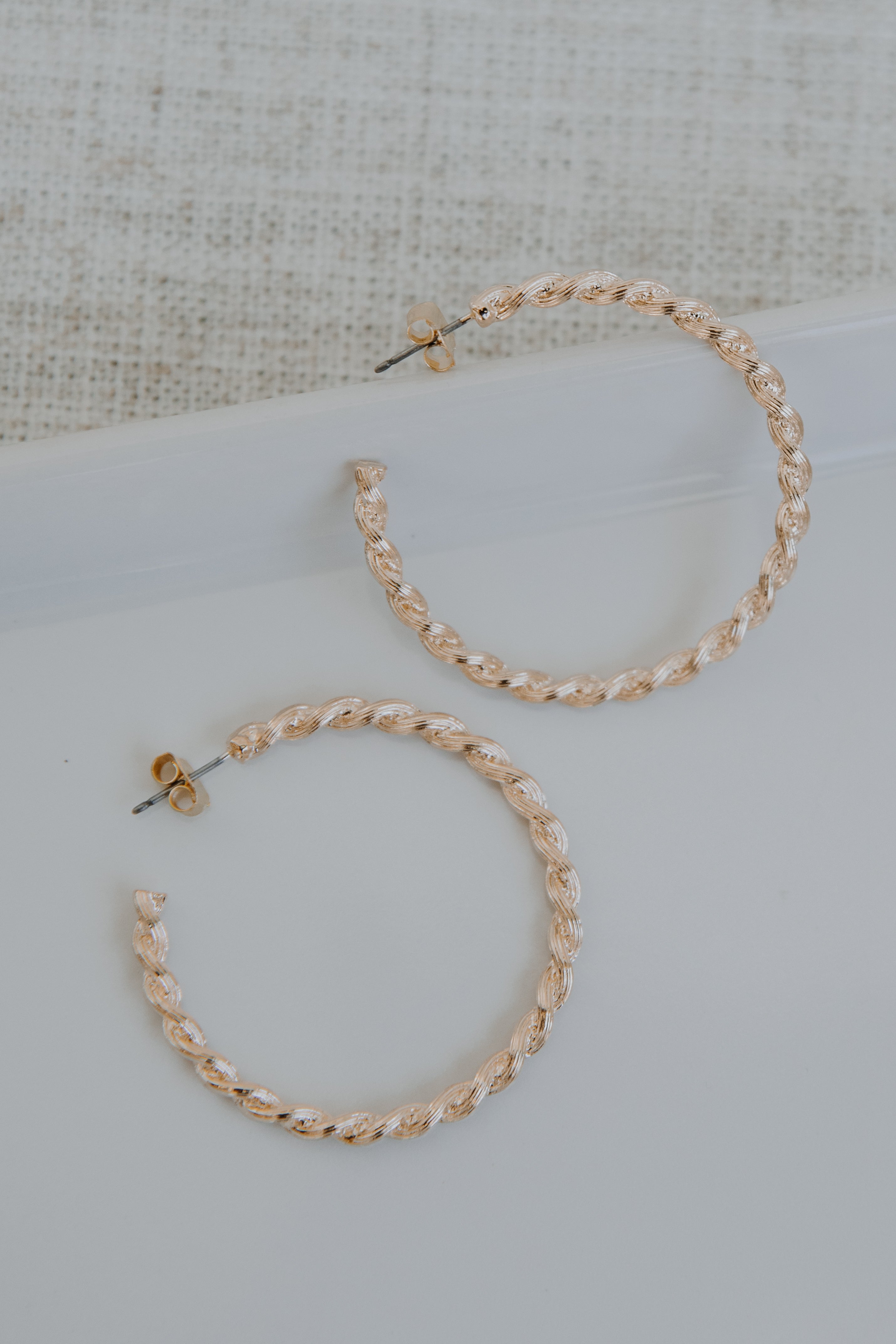 Gold Twisted Hoop Earrings flat lay