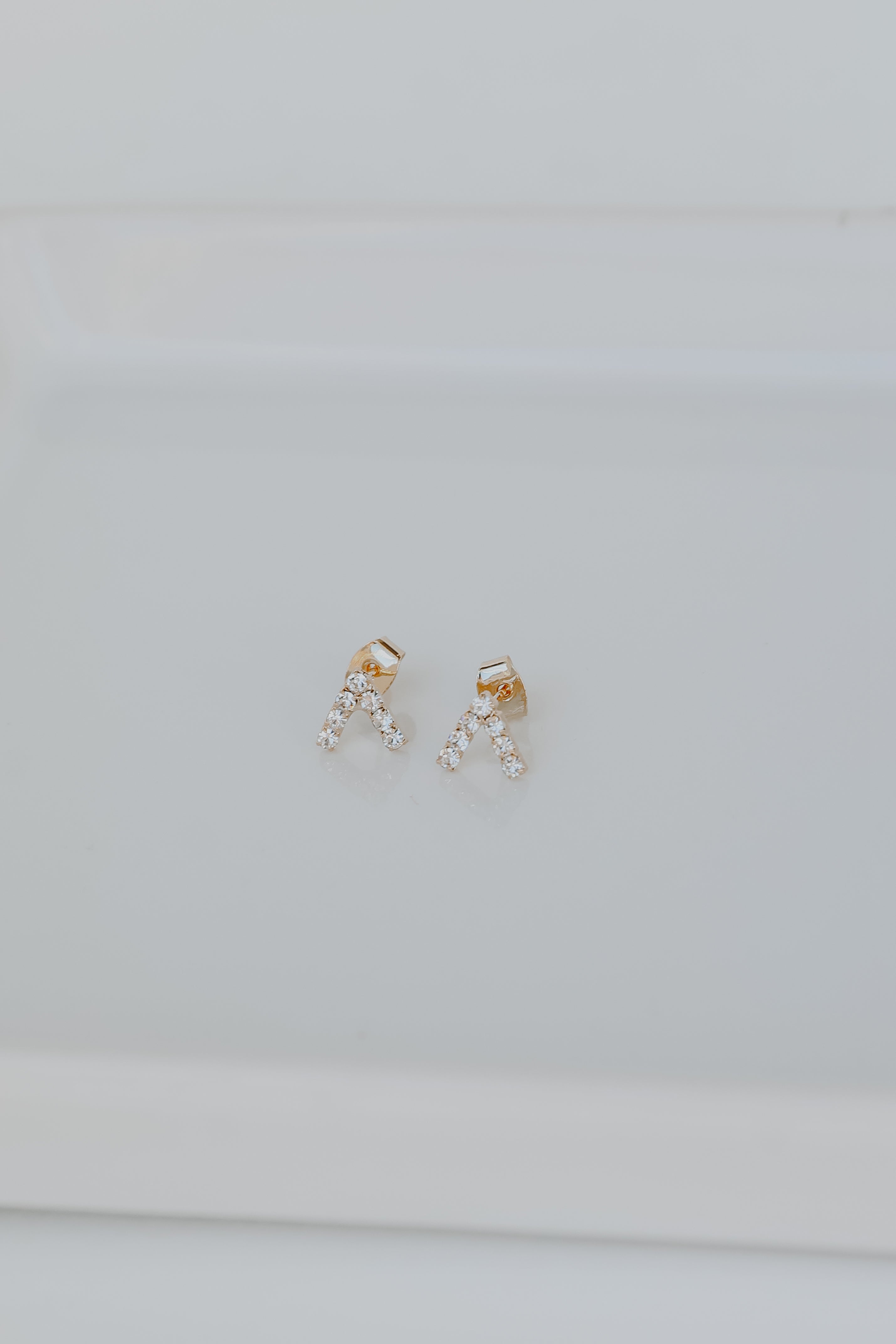 Gold Rhinestone V Stud Earrings flat lay
