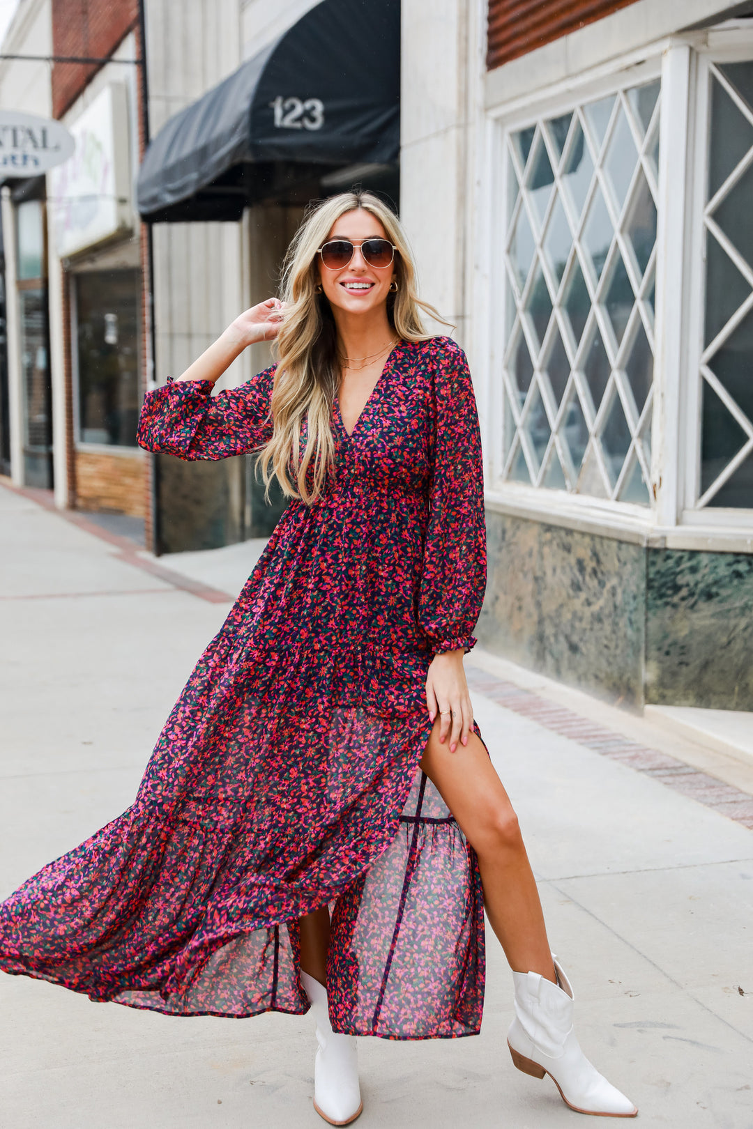 model wearing maxi length floral dress with white cowboy booties
