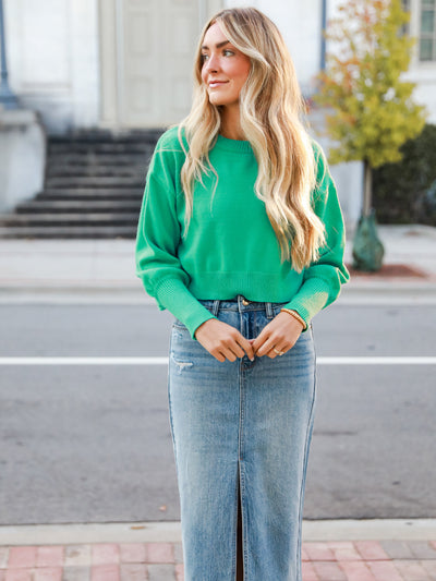 dress up model wearing trending denim skirt outfit idea with green sweater
