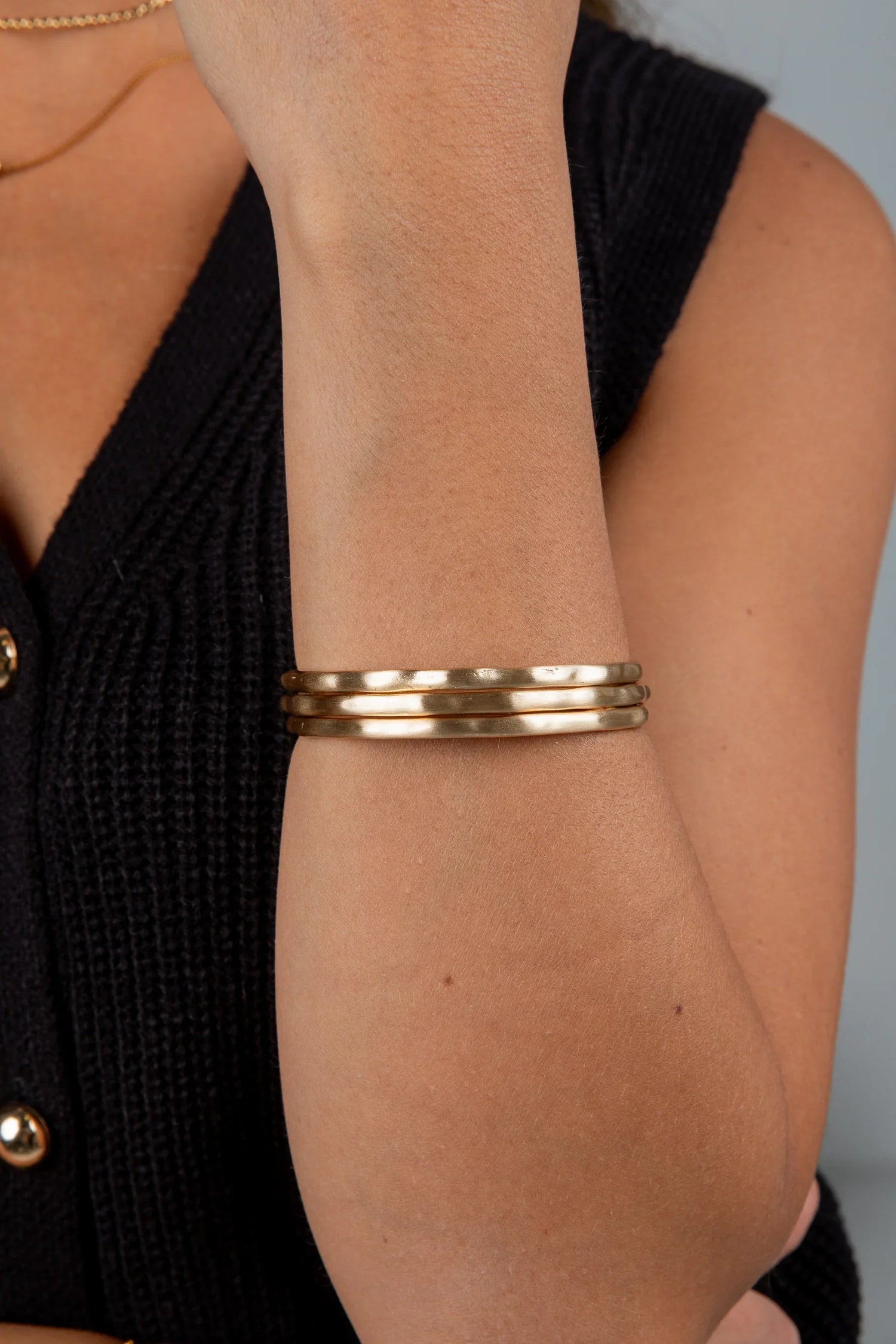 Woman wearing gold bangle bracelet set