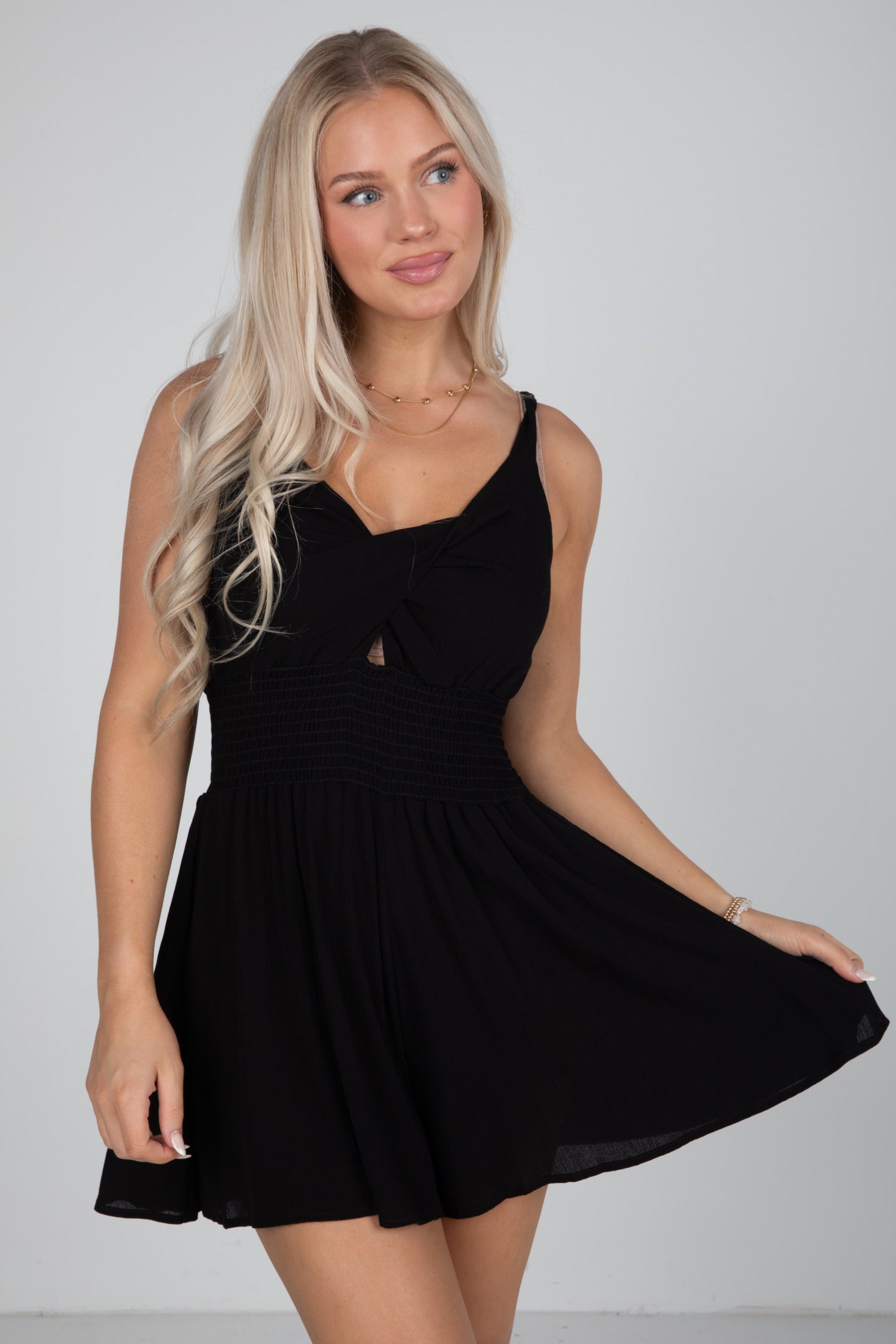 Woman wearing a black dress against a plain background