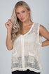 Woman wearing a beige crochet sleeveless top against a plain background
