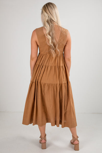 Woman wearing a brown dress with a plain background