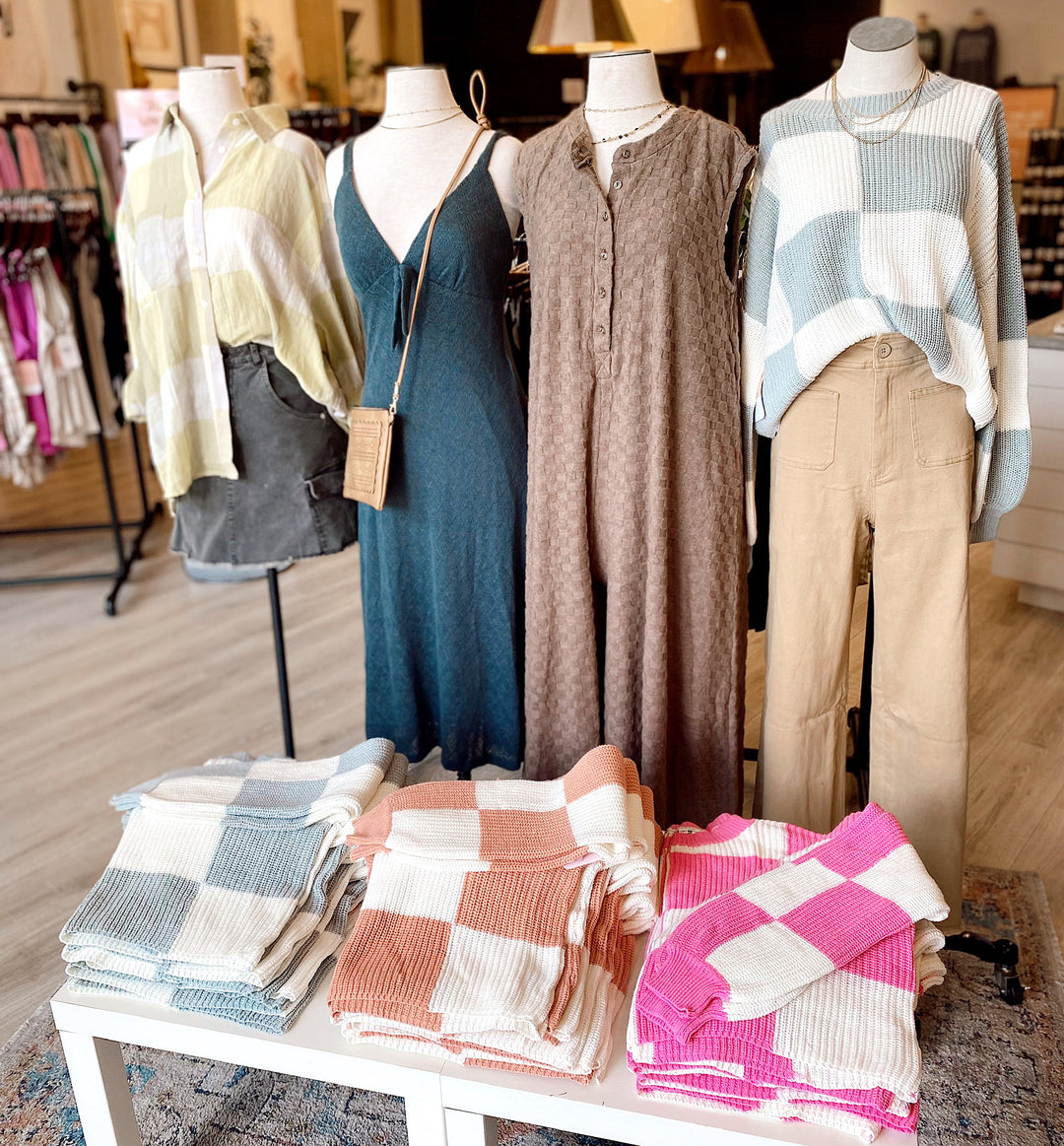 Collection of sweaters, jumpsuits, and knit dresses at our Dress Up Suwanee Location