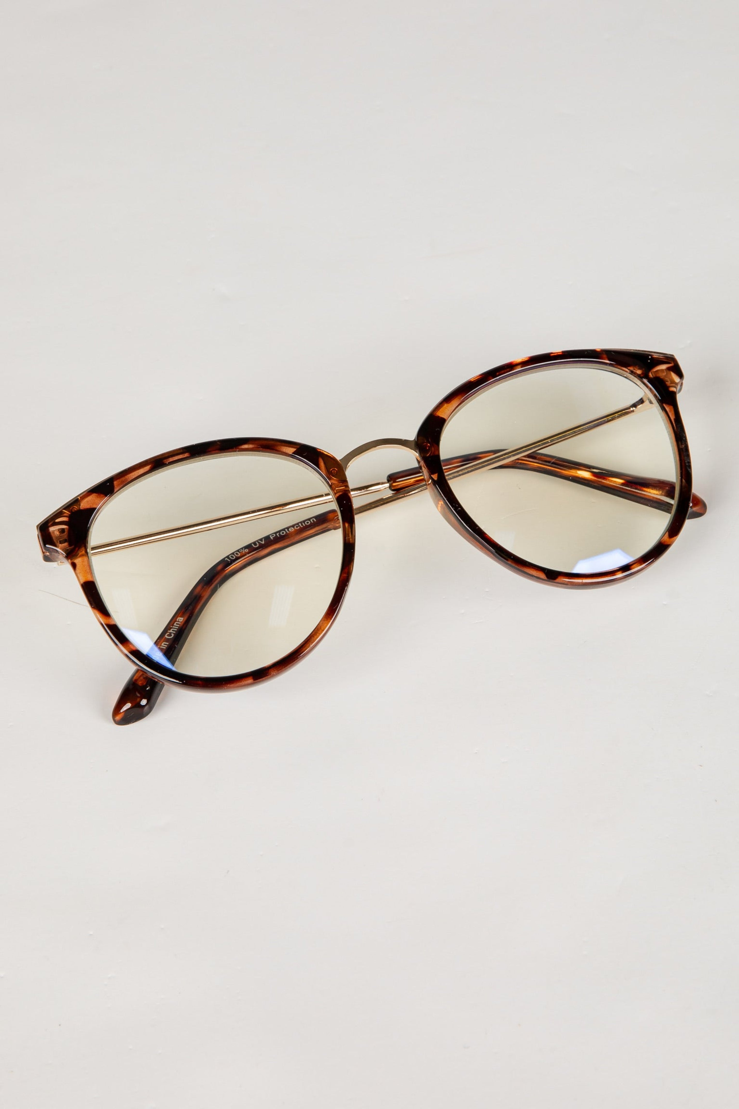 Tortoiseshell cat-eye glasses on a light gray background