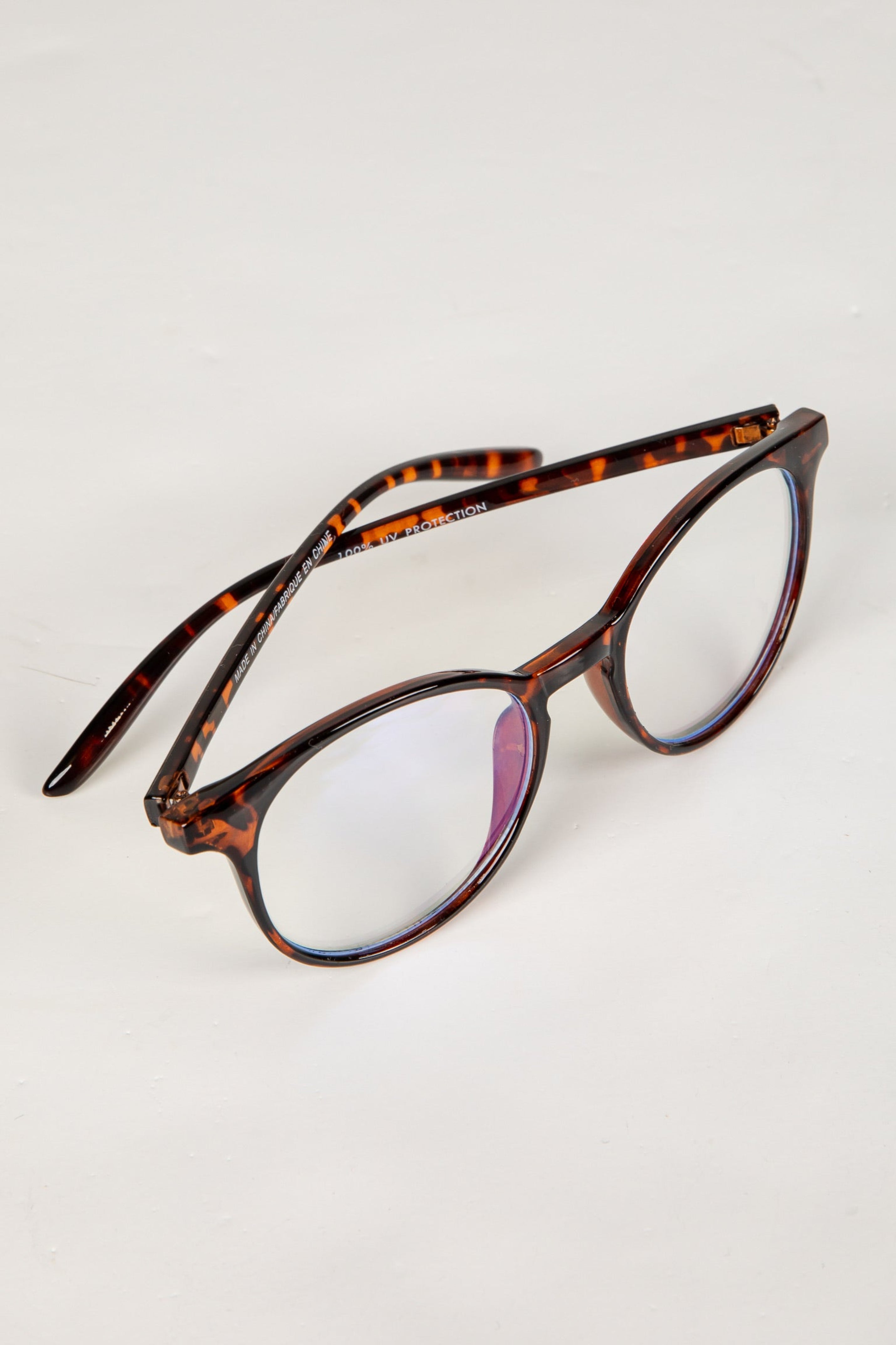 Tortoiseshell eyeglasses on a light gray background
