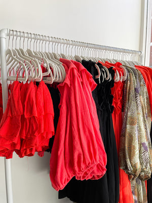 dress up women's clothing boutique showing clothes hanging on a shopping rack