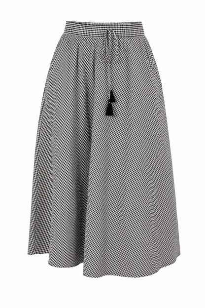 A black and white micro-check patterned midi skirt with a drawstring waist and a black tassel accent, shown against a plain white background.