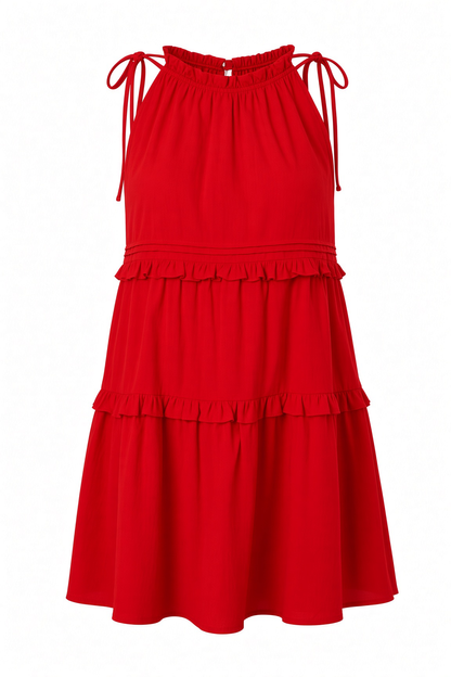A bright red sleeveless halter dress with tie straps at the shoulders, a smocked bodice, and two ruffled tiers on a white background.