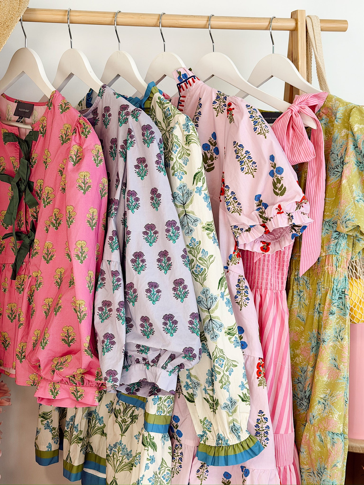 Colorful womens clothing on hangers against a white wall. spring and summer tops and dresses