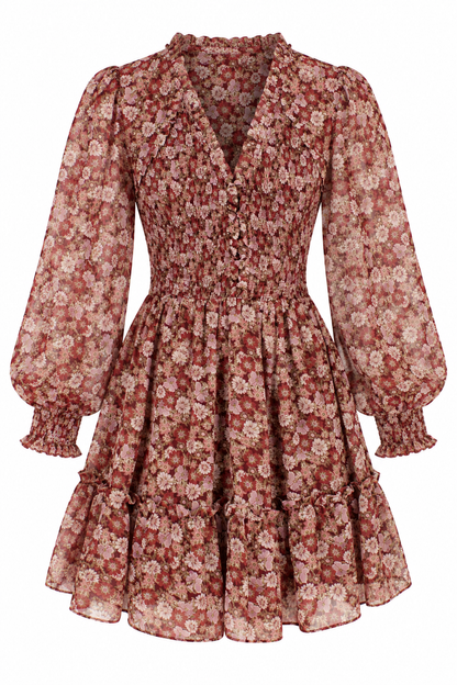 A long-sleeve, smocked, tiered mini dress with a dense floral pattern in dusty rose, rust red, and cream, shown against a plain white background.